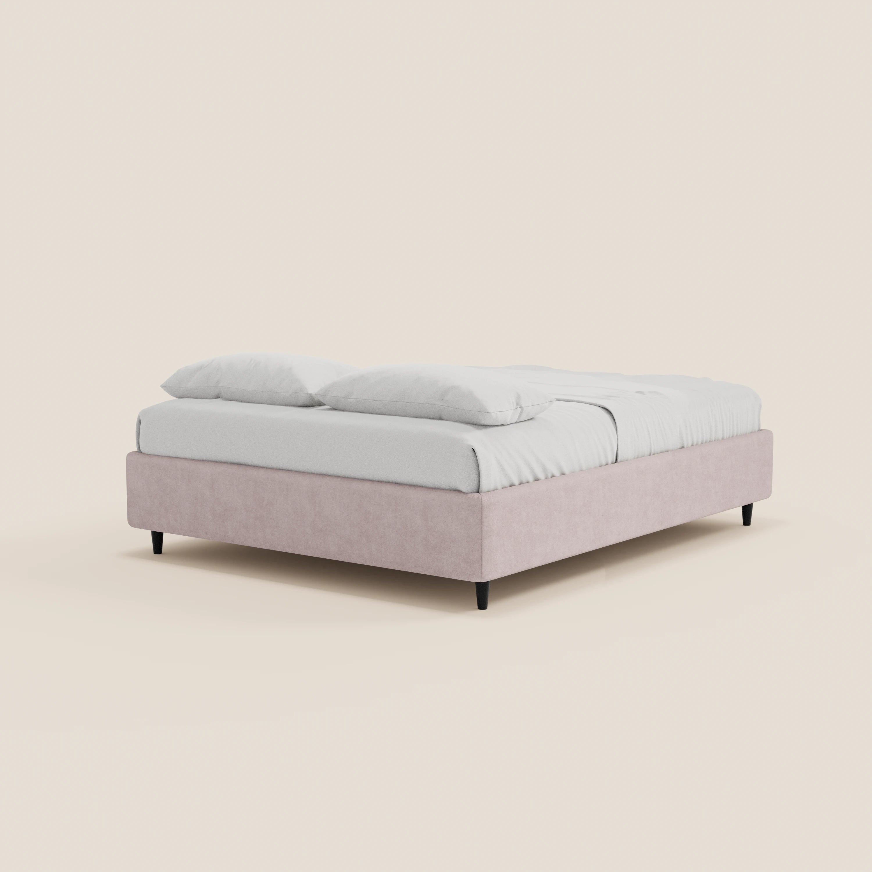 Il letto sommier ERON di Letti.store è un letto moderno dal profilo basso, realizzato in tessuto impermeabile Oeko-Tex color rosa pallido, con gambe corte nere e senza testiera, dotato di un vano contenitore che gli conferisce un aspetto elegante e minimalista.