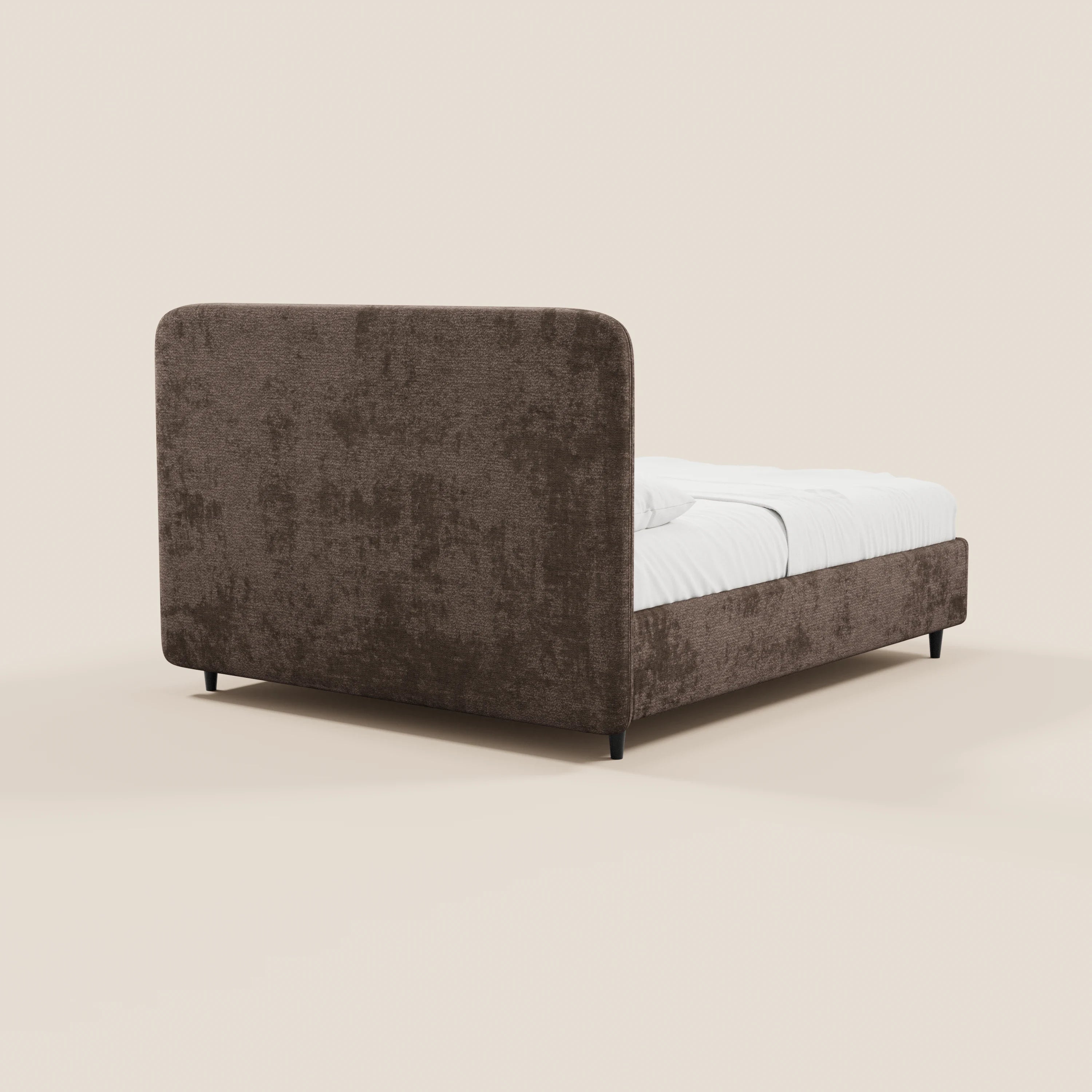 Il letto imbottito KAELOS minimal di Letti.store presenta una testiera arrotondata rivestita in ciniglia, gambe alte, vano contenitore ed un elegante tessuto marrone con trama in rilievo. Nell’immagine è raffigurato con biancheria da letto bianca su uno sfondo beige chiaro, ripreso da un’angolazione posteriore.