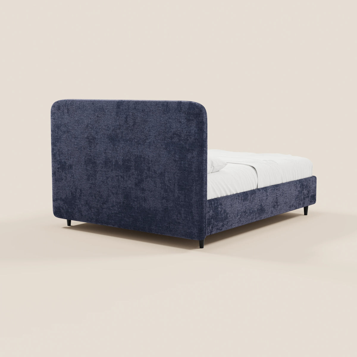 Il letto imbottito KAELOS minimal di Letti.store presenta una struttura rivestita in ciniglia blu scuro e una testiera arrotondata, gambe alte nere e spazio contenitivo. Nell’immagine è raffigurato visto da dietro con una raffinata biancheria da letto bianca su uno sfondo beige chiaro.