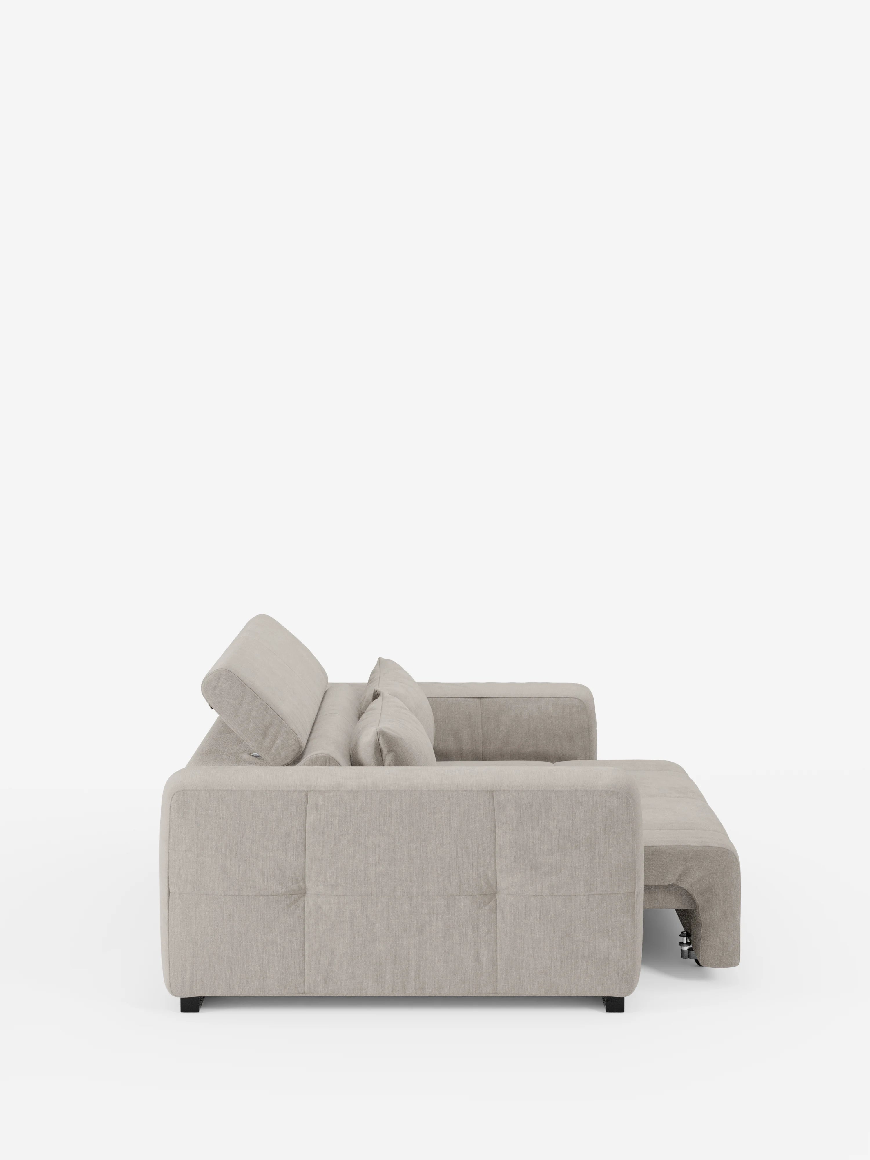 Vista laterale del divano Monarch grigio chiaro con relax elettrico per l’allungamento delle sedute e poggiatesta reclinabile di divitt.sbs, un divano componibile contemporaneo a forma di L rivestito in morbido tessuto smacchiabile T31, caratterizzato da fianchi trapuntati in classico stile capitonné, morbidi cuscini dello schienale e della seduta e gambe corte nere, su uno sfondo bianco a tinta unita. La sezione chaise longue si estende verso destra.