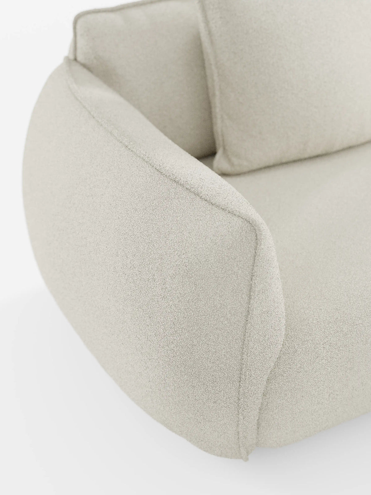 Primo piano del divano Nimbus a 3 posti, modulare e componibile, da 250 cm di divitt.sbs, rivestito in tessuto smacchiabile effetto cotone (tessuto smacchiabile effetto cotone t33) di colore beige chiaro. Ispirata al design dei divani modulari, questa poltrona presenta un bracciolo ricurvo verso l’esterno e uno schienale morbido e imbottito. Il look complessivo è lussuoso e contemporaneo, caratterizzato da linee pulite e arrotondate.