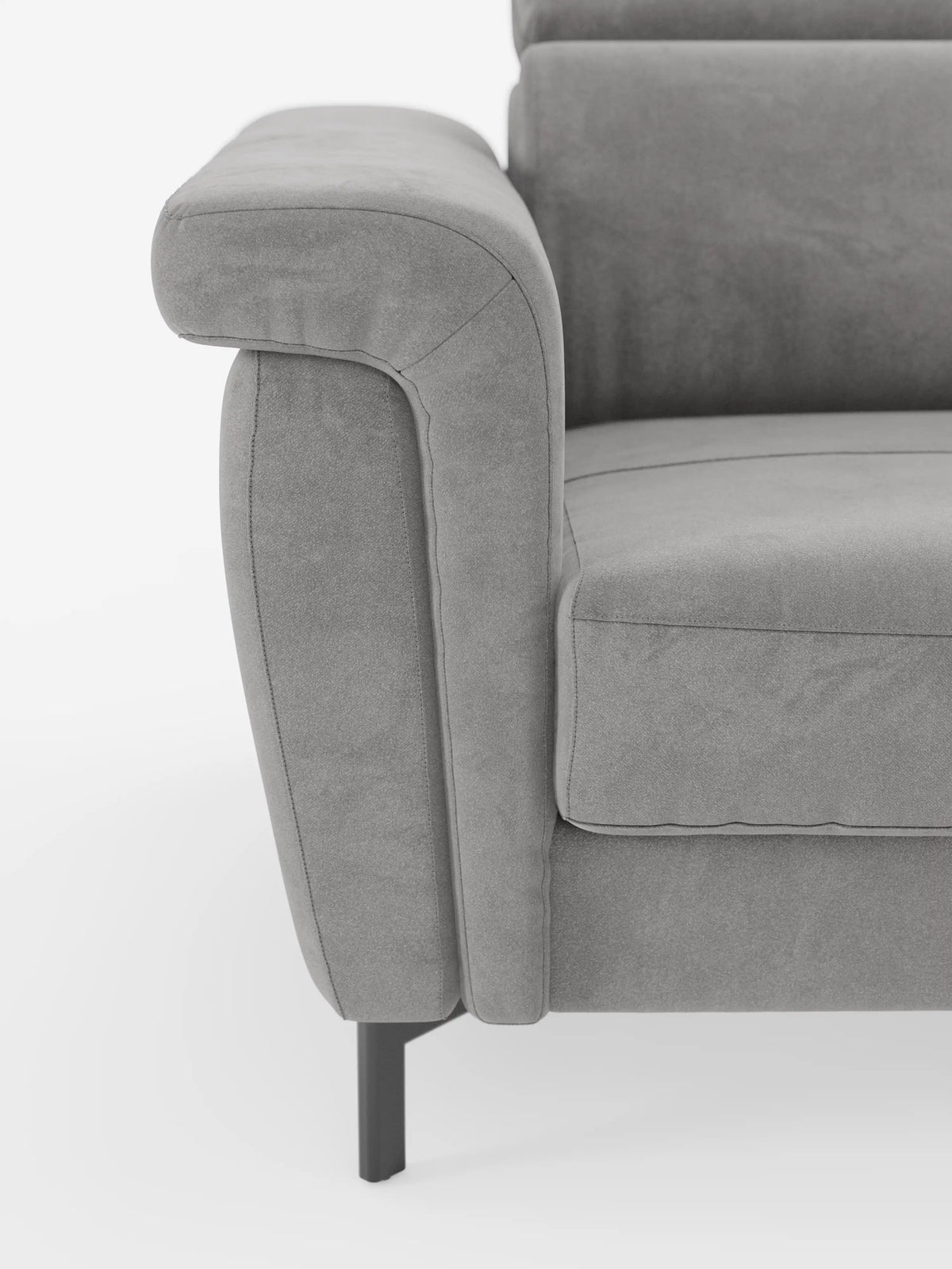Primo piano del bracciolo sinistro e della seduta del divano letto di design Capri di divitt.sbs, caratterizzato da alte gambe in metallo nero, morbido tessuto T30 effetto velluto simile alla pelle scamosciata e smacchiabile, e imbottitura morbida e raffinata con poggiatesta regolabili, ripreso su uno sfondo bianco a tinta unita.