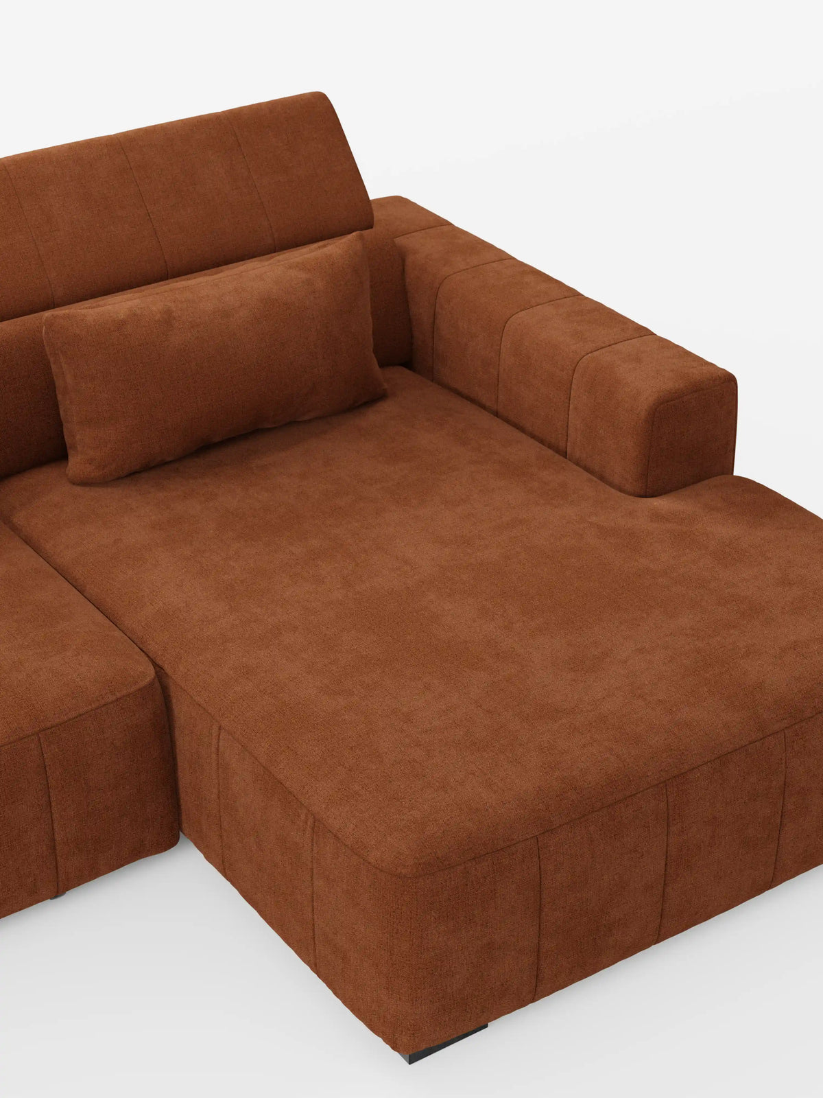 Un divano angolare in stile dorico contemporaneo con penisola e sedute allungabili con funzione relax elettrica di divitt.sbs, presentato in morbido tessuto T23 marrone smacchiabile, caratterizzato da una spaziosa chaise longue, uno schienale rettangolare basso con poggiatesta regolabili, un bracciolo sul lato destro e un cuscino rettangolare abbinato. Lo sfondo è bianco a tinta unita.