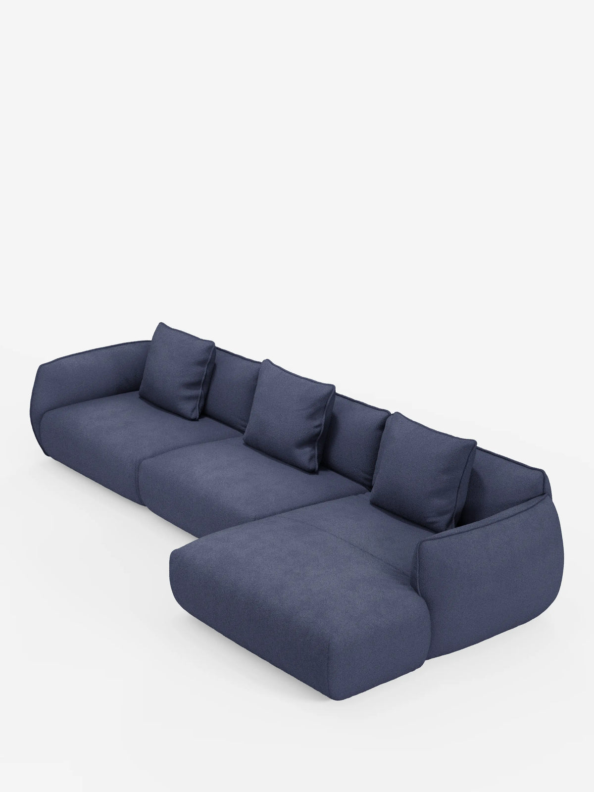 Un divano angolare contemporaneo Nimbus con penisola componibile di divitt.sbs, rivestito in morbido tessuto T33 effetto cotone, resistente alle macchie, in blu scuro, con quattro cuscini dello schienale, una chaise longue estesa sul lato destro e bordi arrotondati che ne definiscono l’estetica moderna e minimalista, il tutto su uno sfondo bianco a tinta unita.
