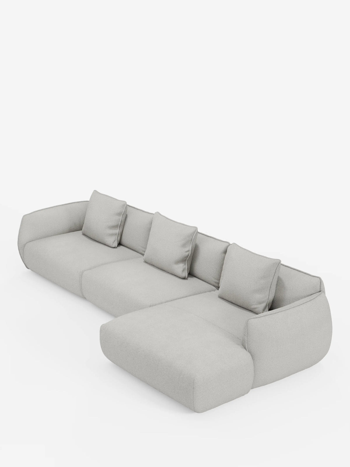 Il divano angolare con penisola componibile Nimbus in morbido tessuto effetto cotone smacchiabile T33 di divitt.sbs è un divano componibile moderno, di colore grigio chiaro, con la chaise longue posizionata sul lato destro. Questo divano moderno è dotato di quattro cuscini dello schienale coordinati e braccioli arrotondati, tutti rivestiti in un tessuto morbido, soffice e antimacchia effetto cotone. Il divano è presentato su uno sfondo bianco a tinta unita.