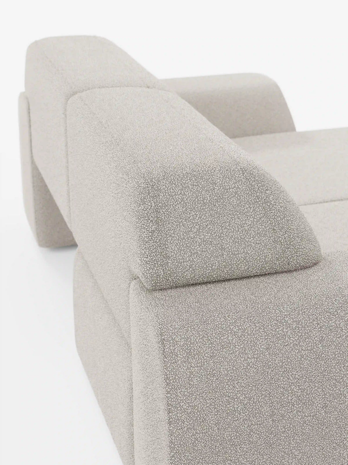 Primo piano del divano Orbit a 2 e 3 posti con sedute scorrevoli di divitt.sbs, interamente rivestito in tessuto T33 effetto cotone beige chiaro antimacchia, caratterizzato da linee pulite, braccioli bassi e larghi e un design geometrico minimalista — con rivestimenti completamente sfoderabili — su uno sfondo bianco a tinta unita.