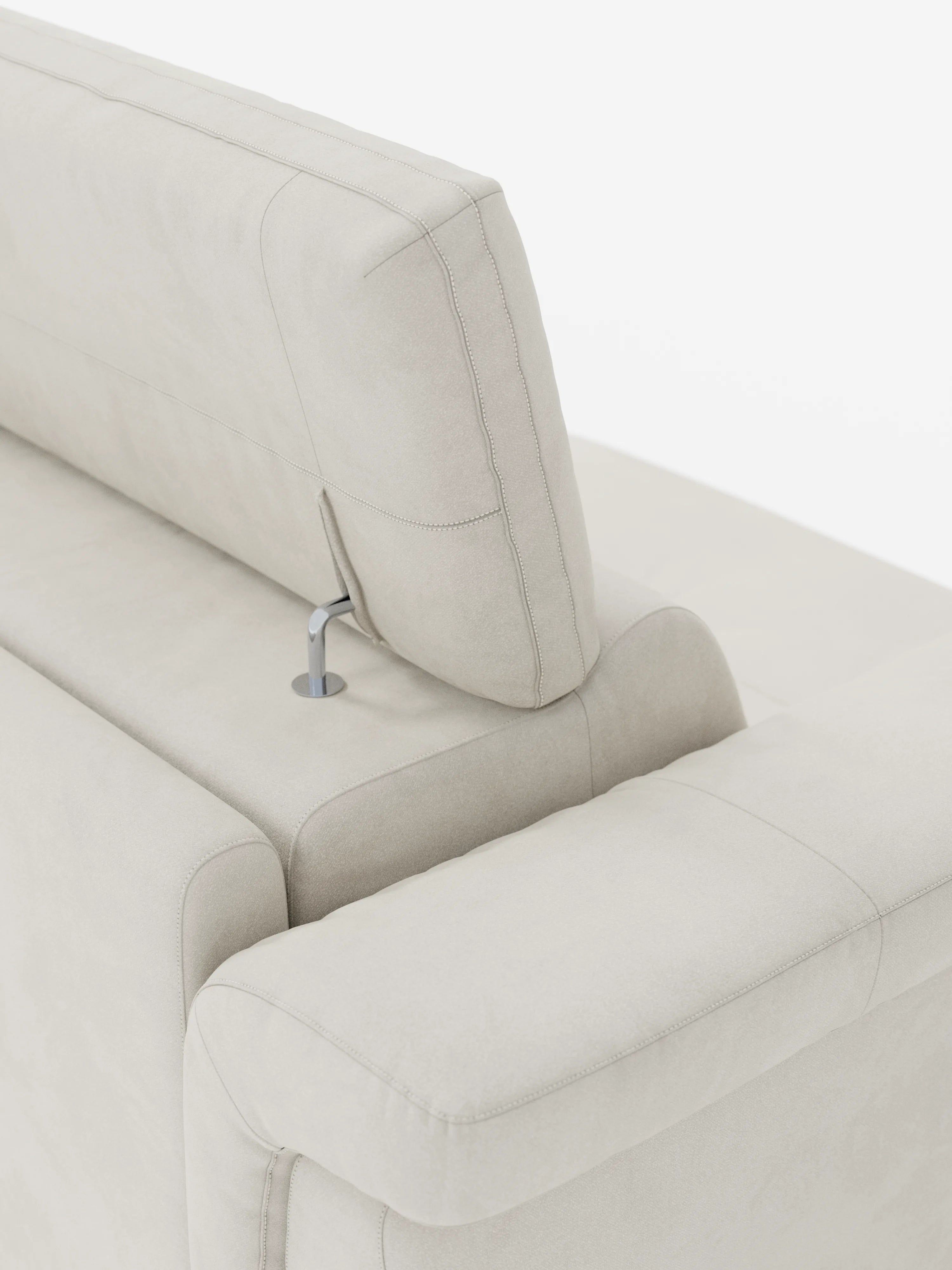 Primo piano del divano letto di design Capri con piedini alti di divitt.sbs in una tonalità beige chiaro, caratterizzato da un poggiatesta mobile fissato allo schienale tramite un supporto metallico a vista. I poggiatesta reclinabili sono rivestiti in raffinato tessuto effetto velluto smacchiabile T30, che appare morbido, liscio e con cuciture minime. L'immagine è inquadrata su uno sfondo bianco a tinta unita.