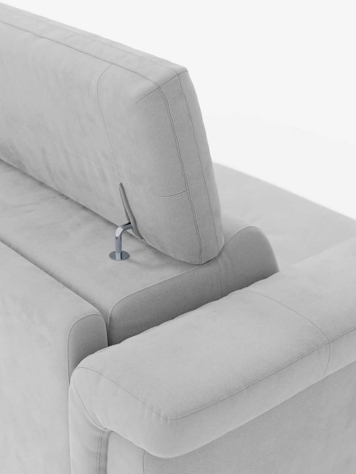 Un primo piano del divano letto di design Capri con piedini alti di divitt.sbs, rivestito in raffinato tessuto T30 effetto velluto, resistente alle macchie, in grigio chiaro. L'immagine mette in risalto il poggiatesta regolabile, dotato di un elegante meccanismo di regolazione in metallo e di morbidi cuscini, il tutto presentato su uno sfondo bianco minimalista e ben illuminato per esaltarne l'artigianalità italiana.