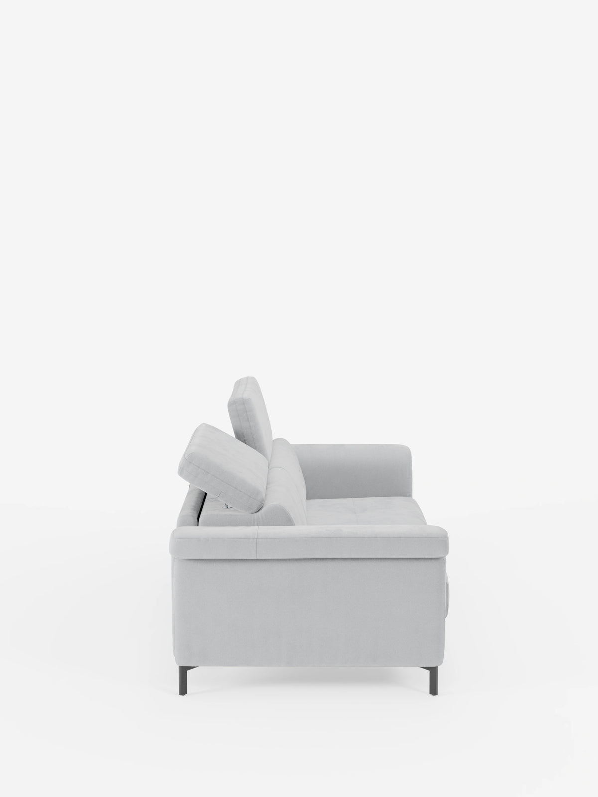 Un moderno divano letto di design Capri di divitt.sbs, rivestito in raffinato tessuto effetto velluto grigio chiaro resistente alle macchie (T30), è ripreso di profilo su uno sfondo bianco a tinta unita. Questo divano presenta braccioli dritti, cuscini dello schienale angolati con poggiatesta regolabili, gambe alte e sottili di colore nero e linee pulite e minimaliste, che rispecchiano la raffinata manifattura italiana.