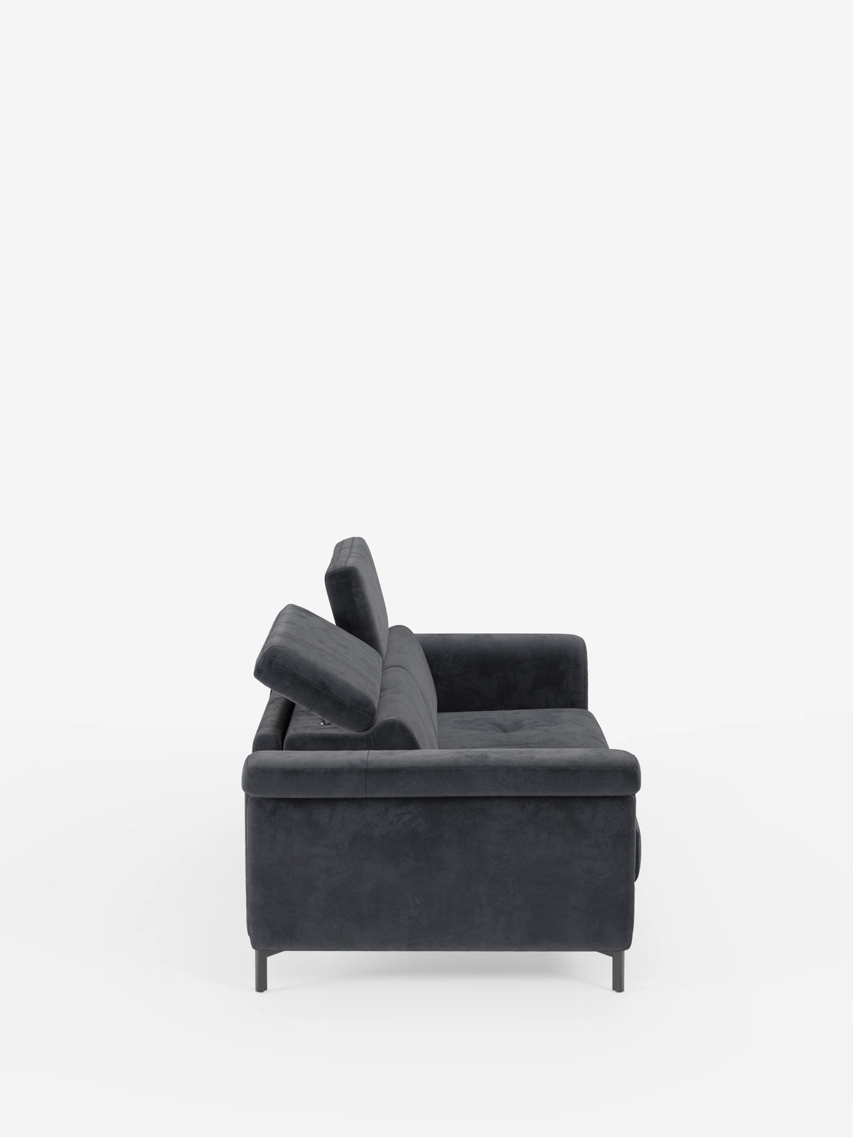 Vista laterale del divano letto di design Capri di divitt.sbs, caratterizzato da un tessuto effetto velluto smacchiabile T30 grigio scuro e resistente alle macchie, poggiatesta regolabili, morbidi cuscini e sottili gambe alte nere — esempio di manifattura italiana — su uno sfondo bianco a tinta unita.