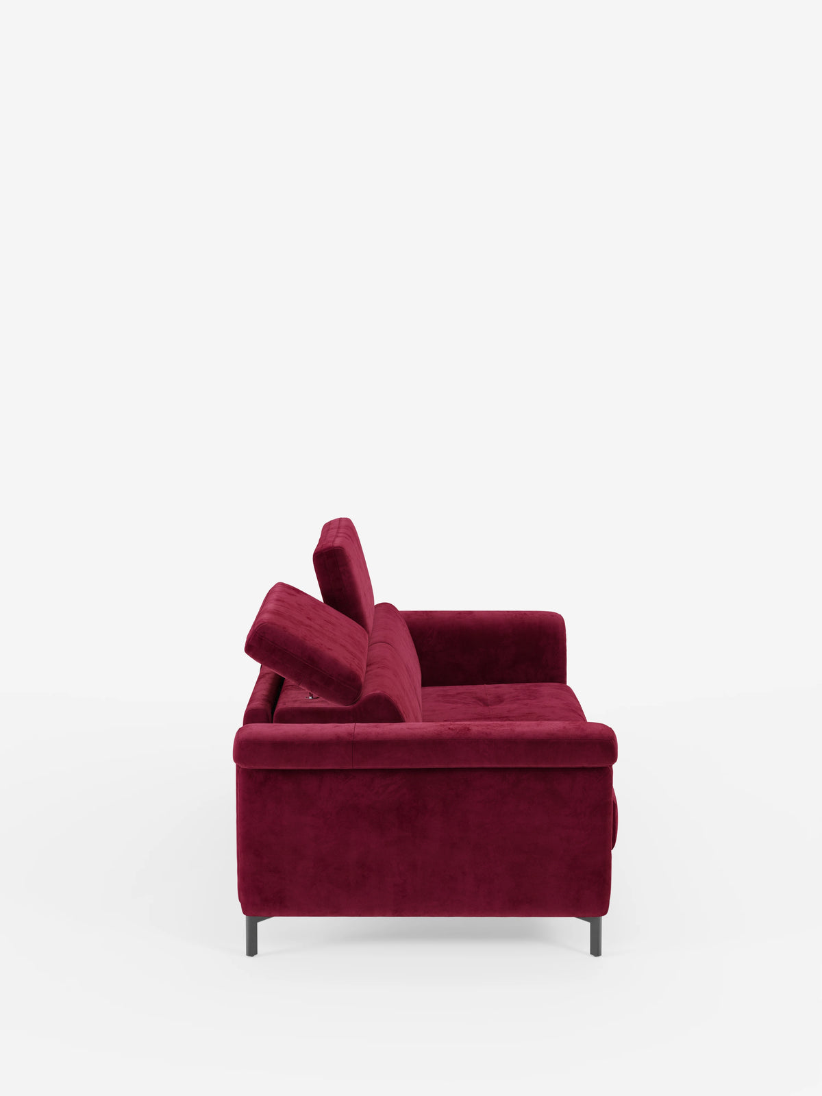 Una vista laterale del divano letto di design Capri di divitt.sbs, presentato in un rosso intenso, caratterizzato da gambe alte nere e manifattura italiana. Questo divano moderno vanta un'imbottitura spessa, braccioli bassi e poggiatesta reclinabili regolabili, il tutto rivestito in un lussuoso tessuto effetto velluto smacchiabile T30, resistente alle macchie, che risalta su uno sfondo bianco a tinta unita.
