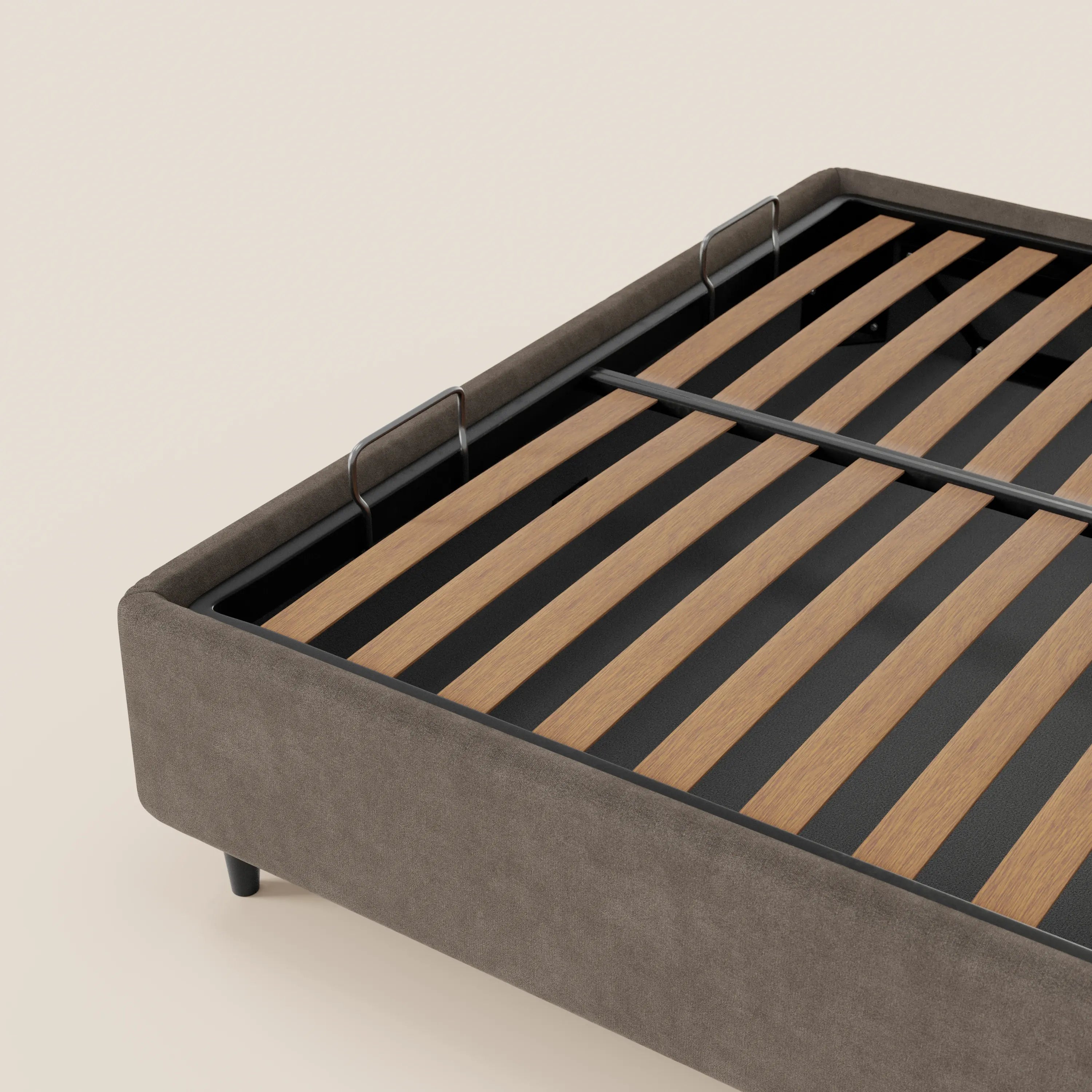 Un primo piano del letto sommier imbottito con contenitore ERON di Letti.store, caratterizzato da una base in tessuto grigio impermeabile certificato Oeko-Tex, montanti in metallo nero, doghe in legno e gambe corte nere su uno sfondo chiaro.