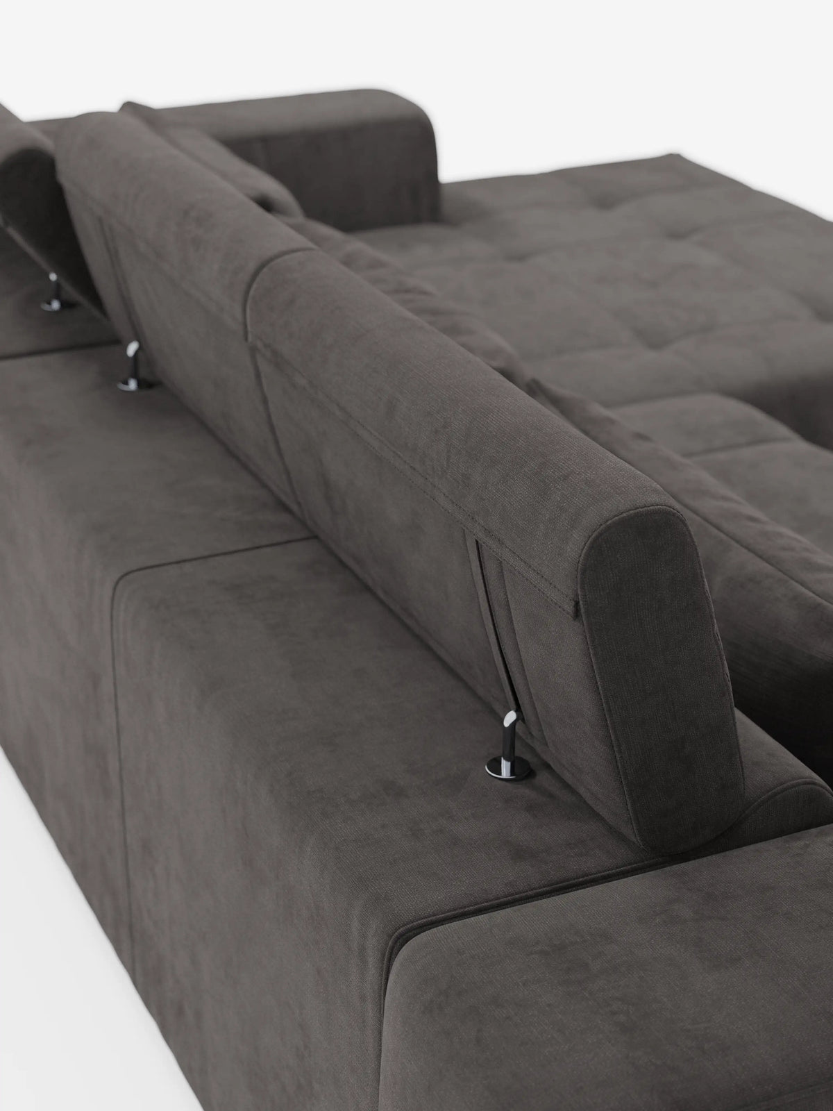 Il divano angolare Monarch con penisola e funzione relax elettrica per l’allungamento delle sedute di divitt.sbs è presentato in tessuto T31 grigio scuro, morbido e resistente alle macchie. I poggiatesta regolabili del divano sono posizionati in posizione verticale, mettendo in risalto le sue linee pulite e moderne e i cuscini trapuntati in un sobrio stile capitonné. Fotografato da un’angolazione posteriore su sfondo bianco, il design contemporaneo del divano modulare è chiaramente visibile.