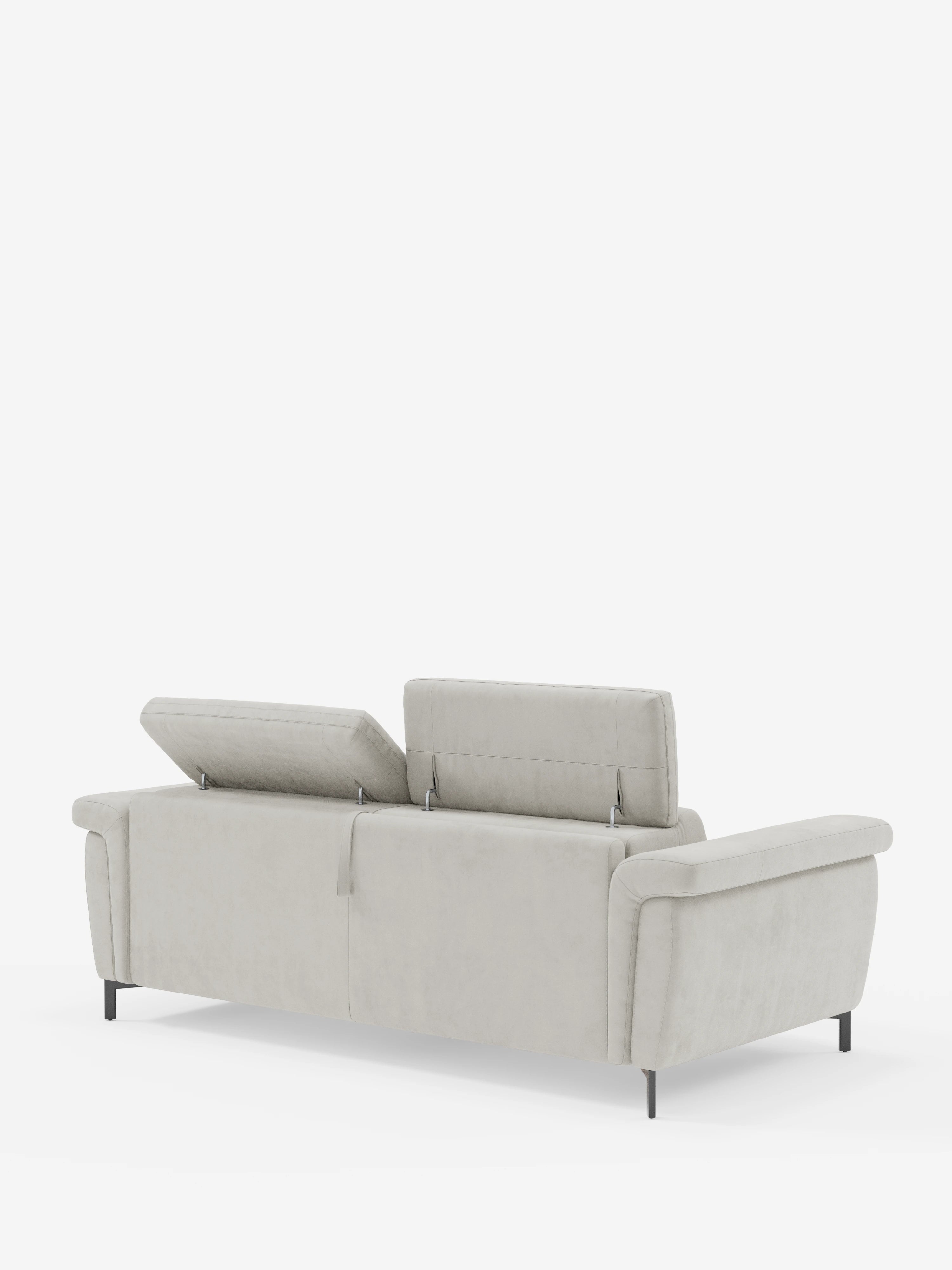 Il divano letto di design Capri con piedini alti di divitt.sbs è presentato nella vista posteriore, rivestito in un moderno tessuto T30 grigio chiaro effetto velluto, resistente alle macchie. È dotato di tre poggiatesta regolabili — due in posizione verticale e uno parzialmente reclinabile — e poggia su gambe nere eleganti e slanciate. Questo divano minimalista incarna la raffinata manifattura italiana, fondendo perfettamente stile e funzionalità su uno sfondo bianco a tinta unita.