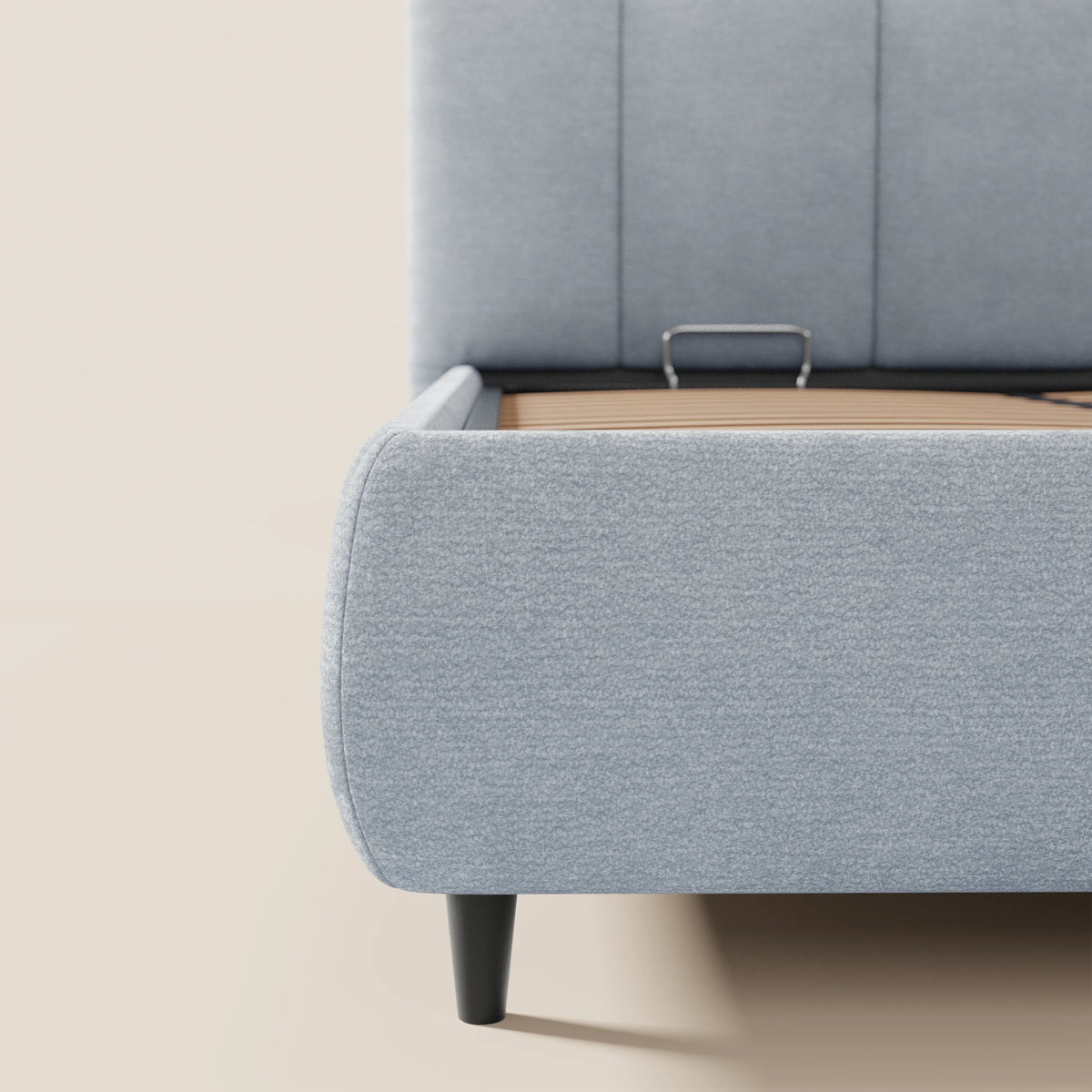 Primo piano del letto imbottito ARKAM di Letti.store, caratterizzato da un design shabby chic con testiera cucita verticalmente in tessuto certificato Oeko-Tex® e base contenitiva ribaltabile, in contrasto con la parete e il pavimento chiari.