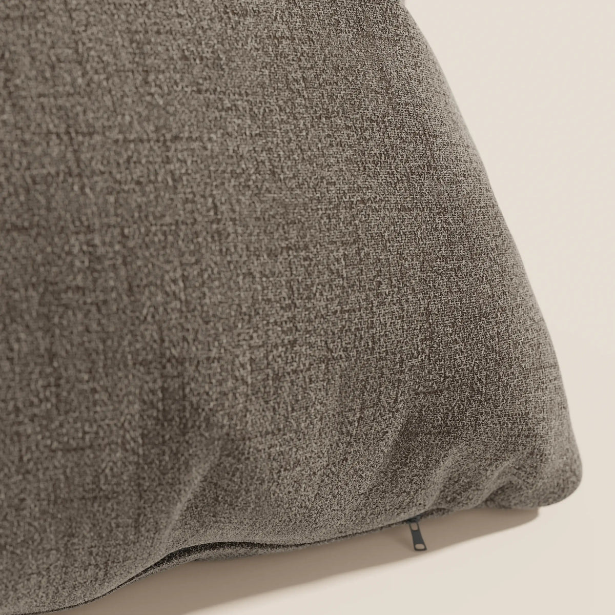 Primo piano del cuscino Felis di divitt.sbs in morbido tessuto impermeabile T03 marrone, caratterizzato da una trama intrecciata e da una cerniera a vista, perfetto per un uso decorativo su sfondi neutri.