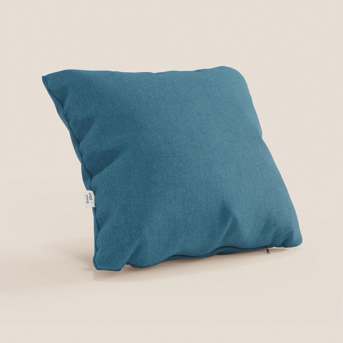 Il cuscino quadrato Honey 45x45 in azzurro T13 di divitt.sbs, realizzato in tessuto simil-cotone impermeabile, è raffigurato su uno sfondo a tinta unita con una piccola etichetta bianca e una discreta cerniera per il rivestimento sfoderabile e lavabile.
