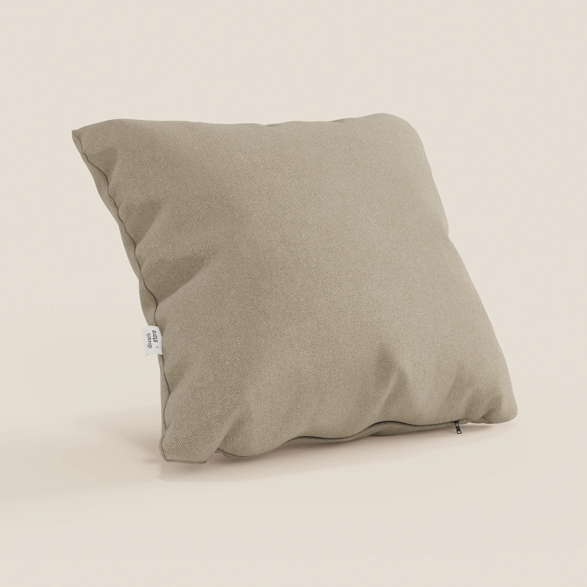 Un cuscino quadrato Honey di divitt.sbs in T13 beige, realizzato in tessuto impermeabile tipo cotone, sta in piedi. La fodera 45x45 ha una consistenza morbida, lievi rughe, una piccola etichetta laterale bianca e una cerniera visibile nell'angolo inferiore.
