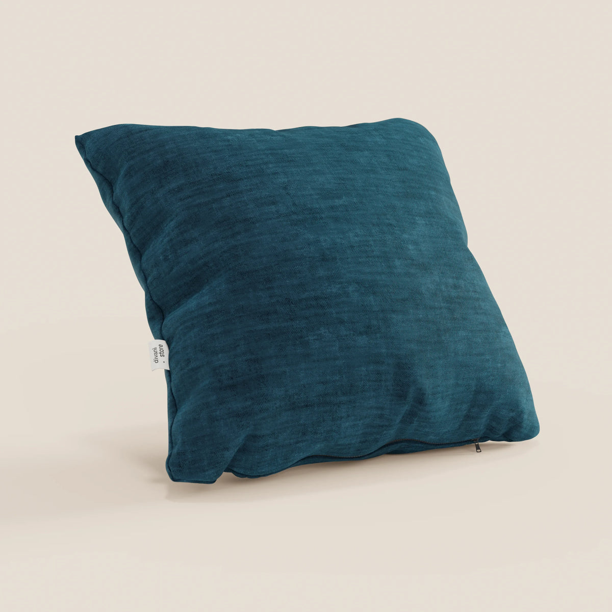 Il cuscino Sofia di divitt.sbs, nella versione quadrata verde-blu, è realizzato in morbido velluto nuvolato Easy Clean T35, impermeabile e antimacchia. Presenta bordi leggermente sgualciti, un'etichetta in tessuto bianco e una cerniera inferiore a vista su sfondo beige.