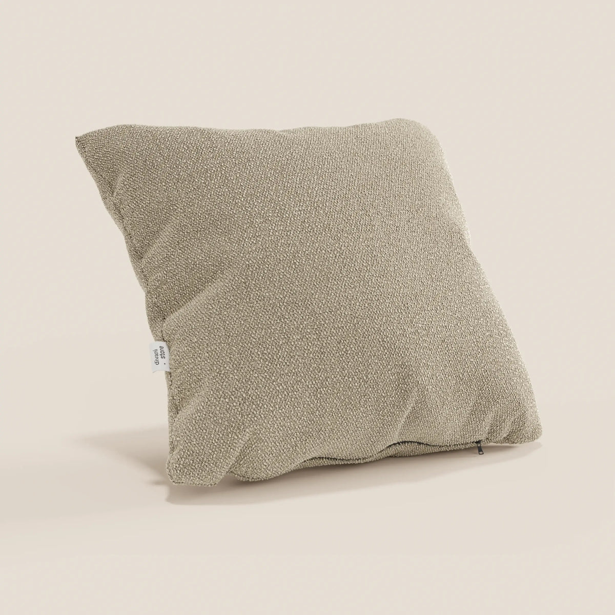 Il cuscino Lambada di divitt.sbs, presentato in beige con una sottile trama intrecciata, presenta una targhetta in tessuto bianco e una cerniera sul fondo. Realizzato in tessuto T33 impermeabile e antimacchia, come il cotone naturale. Disponibile in vari colori.