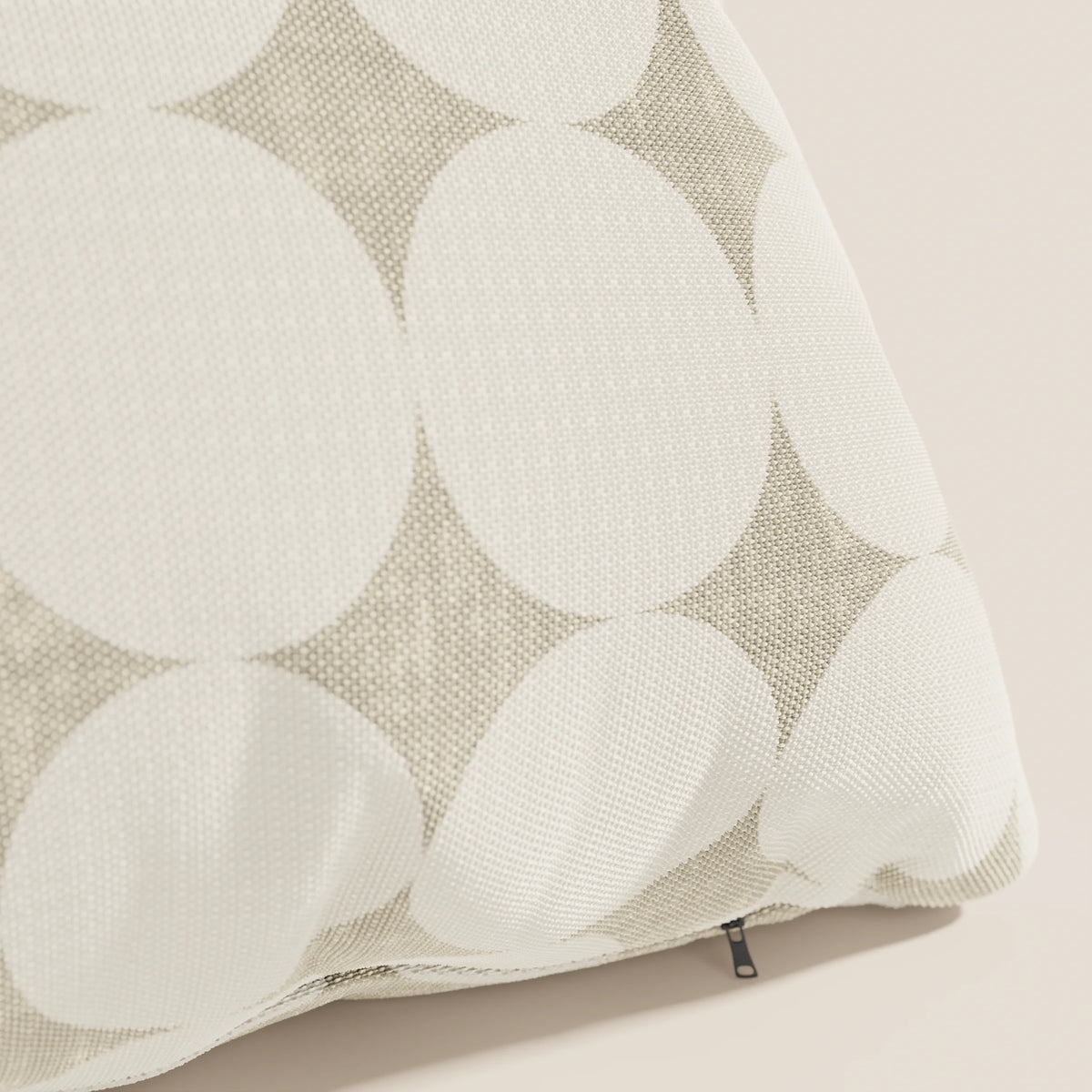 Primo piano dei cuscini geometrici Dot di divitt.sbs, caratterizzati da un coperchio Idrorepellente bianco con grandi cerchi bianchi sovrapposti su beige e da una cerniera nera a vista: una scelta di stile tra i cuscini decorativi.