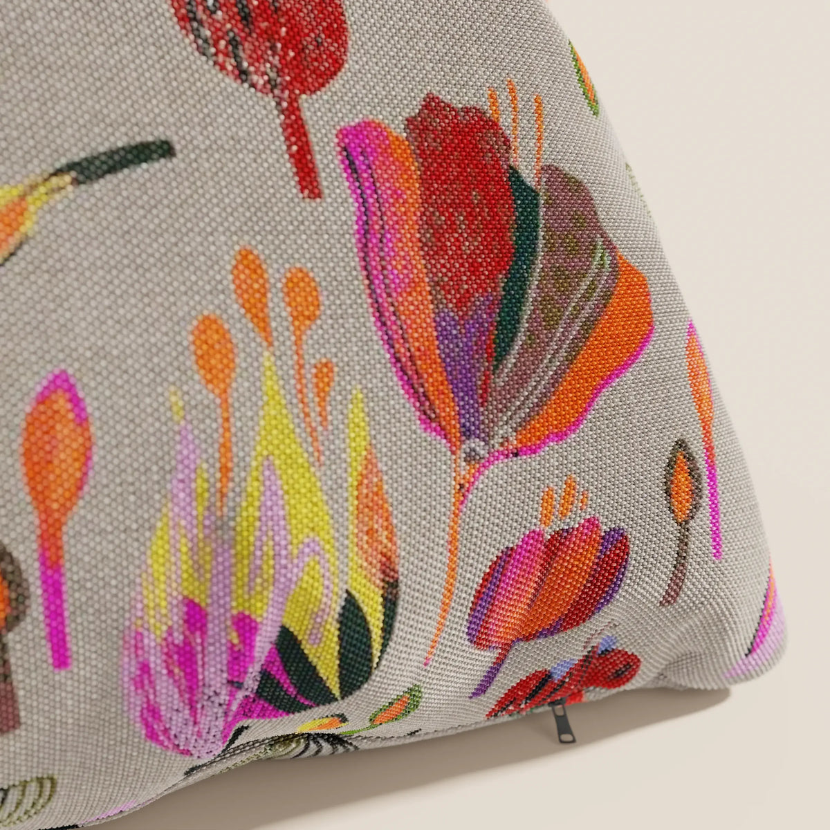 Primo piano del cuscino Joy 45x45 cm di divitt.sbs, in fresco cotone impermeabile grigio con motivo floreale astratto multicolore e cerniera nera a vista sul fondo, della collezione fantasie.