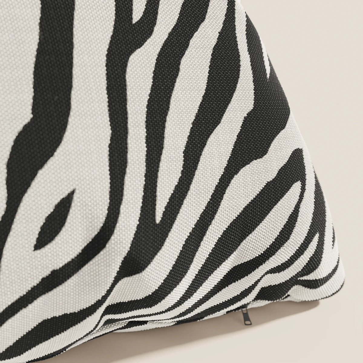Primo piano dello Stripe cuscini geometrici in tessuto idrorepellente di divitt.sbs, caratterizzato da audaci strisce zebrate bianche e nere, una cerniera a vista e un intreccio strutturato, mostrato su uno sfondo neutro per enfatizzare il suo design sorprendente.