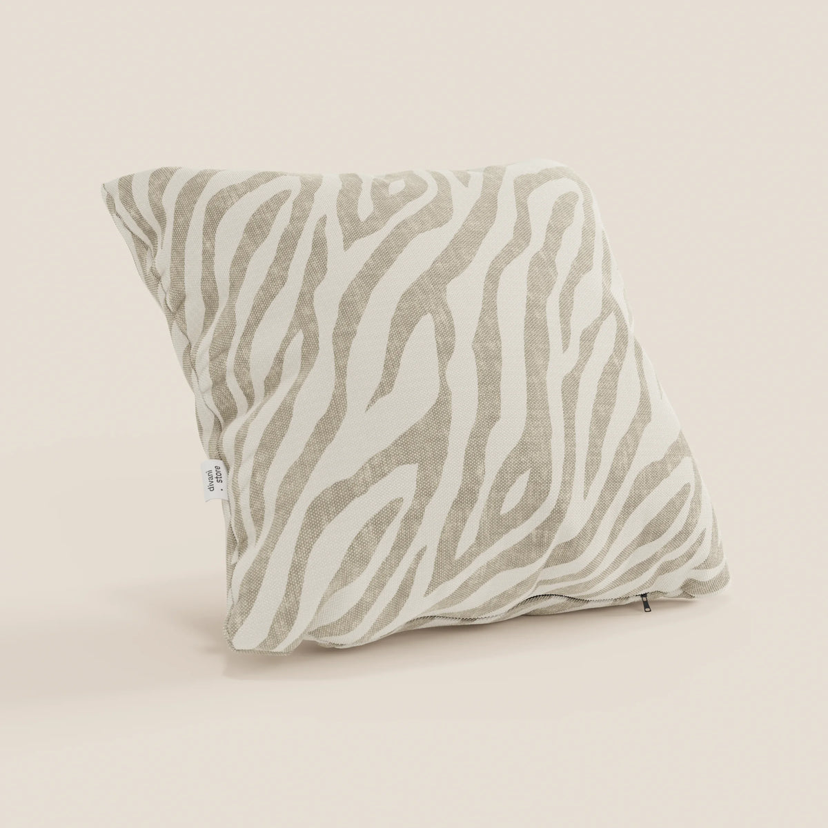 Il cuscino Stripe geometrici in tessuto idrorepellente di divitt.sbs, in beige con motivo zebrato, si erge su uno sfondo chiaro e presenta una piccola etichetta laterale bianca e una cerniera a vista lungo il bordo inferiore.