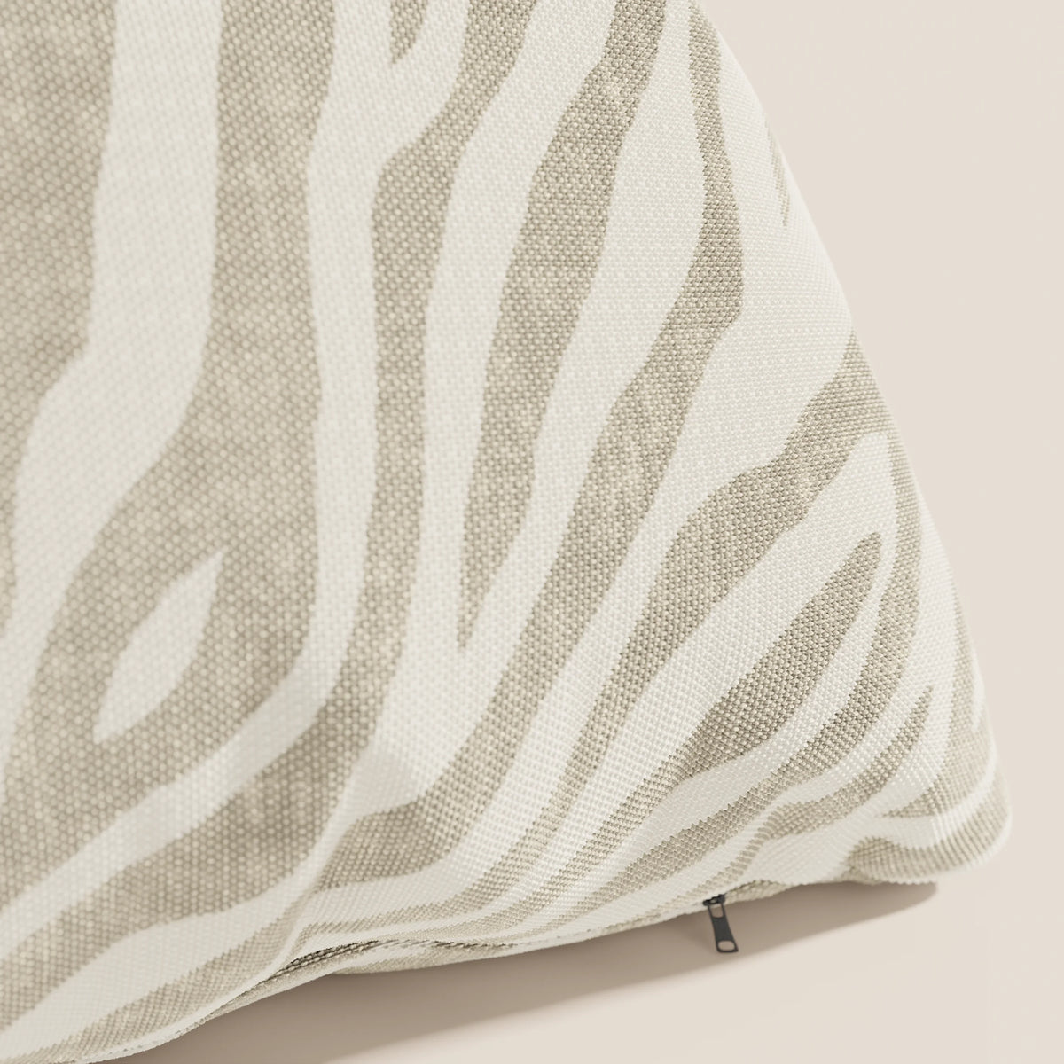 Un primo piano dello Stripe cuscini geometrici in tessuto Idrorepellente di divitt.sbs, che mostra il motivo zebrato beige e la trama intrecciata, con un tiretto nero sul bordo inferiore.