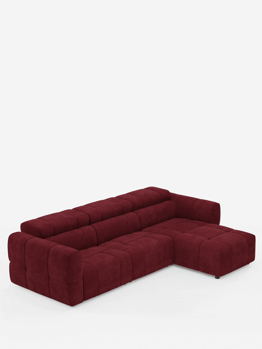 Un divano angolare modulare Giotto rosso intenso a 5 posti, lungo 296 cm, con penisola e funzione relax elettrica opzionale, rivestito in tessuto smacchiabile T23 con finitura a quadretti e design modulare dal profilo ribassato, spicca su uno sfondo bianco a tinta unita.