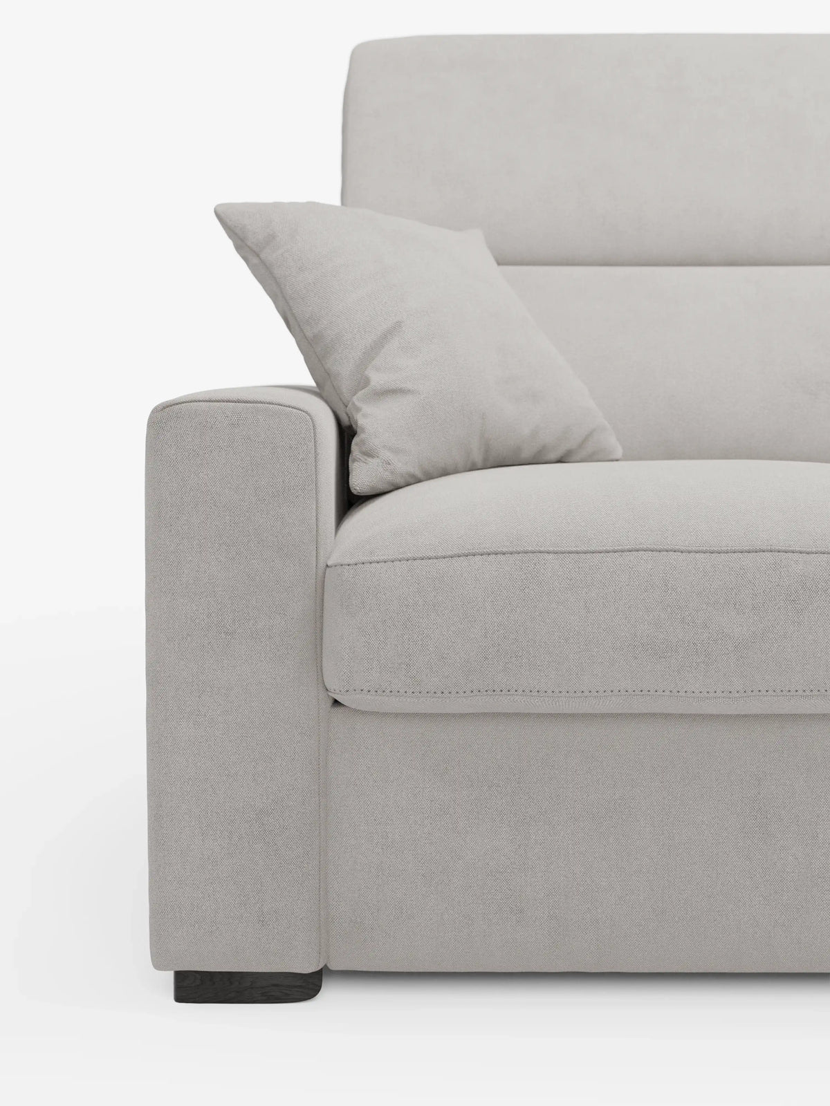 Primo piano del divano letto Maximus a 3 posti con materasso ALTO 20 cm di divitt.sbs, rivestito in grigio chiaro, con particolare attenzione al bracciolo sinistro, al cuscino di seduta e al cuscino decorativo abbinato appoggiato allo schienale. Questo divano letto è dotato di poggiatesta reclinabili e tessuto antimacchia certificato Oeko-Tex, poggia su gambe corte in legno scuro e si distingue su uno sfondo bianco a tinta unita.