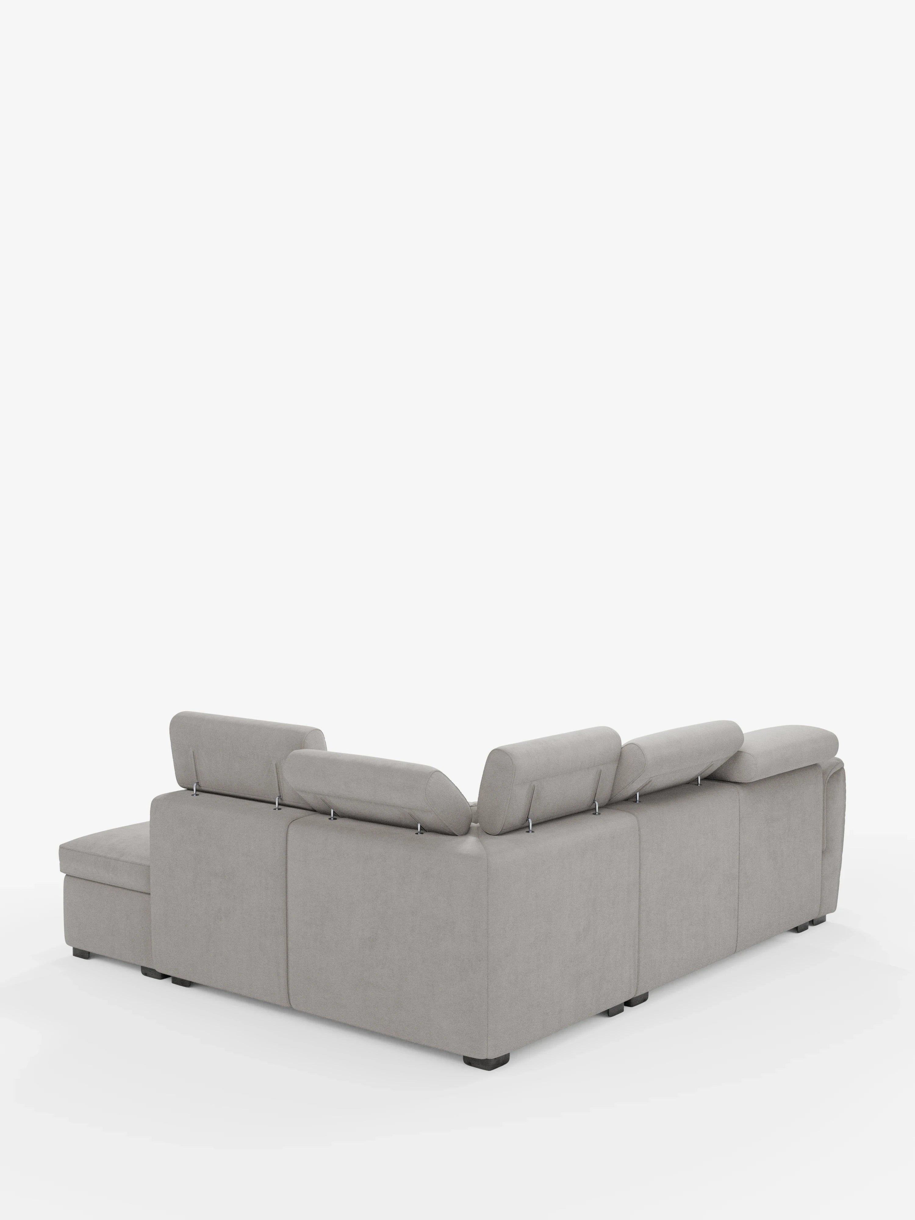 Un divano angolare reversibile Titano grigio chiaro con seduta estraibile e pouf contenitore di divitt.sbs, dotato di poggiatesta reclinabili in tessuto antimacchia certificato Oeko-Tex®, è esposto su uno sfondo bianco. Il divano componibile presenta linee pulite e moderne e piedini neri, con la chaise longue posizionata sul lato sinistro se osservata dall’angolo posteriore.