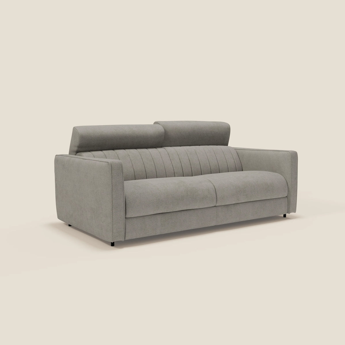 Un moderno divano grigio chiaro con due cuscini di seduta, cuciture verticali sullo schienale, poggiatesta regolabili e ampi braccioli, su uno sfondo beige.