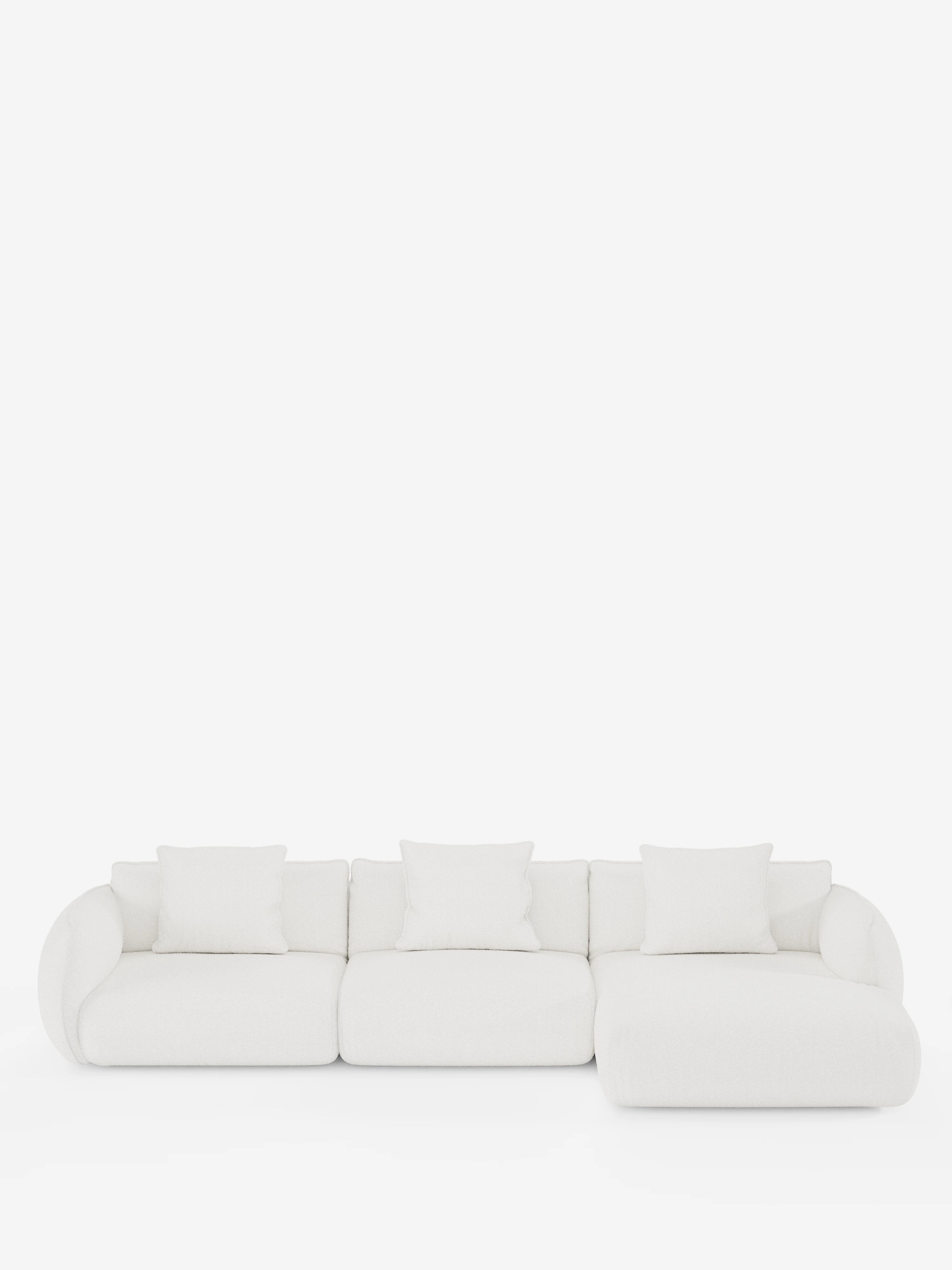 Un moderno divano angolare Nimbus bianco con penisola, della collezione T33 di divitt.sbs, realizzato in morbido tessuto effetto cotone antimacchia, con quattro cuscini quadrati, si staglia su uno sfondo bianco. Il divano presenta braccioli curvi sul lato sinistro e una sezione relax allungata sul lato destro, creando un’estetica minimalista ed elegante.