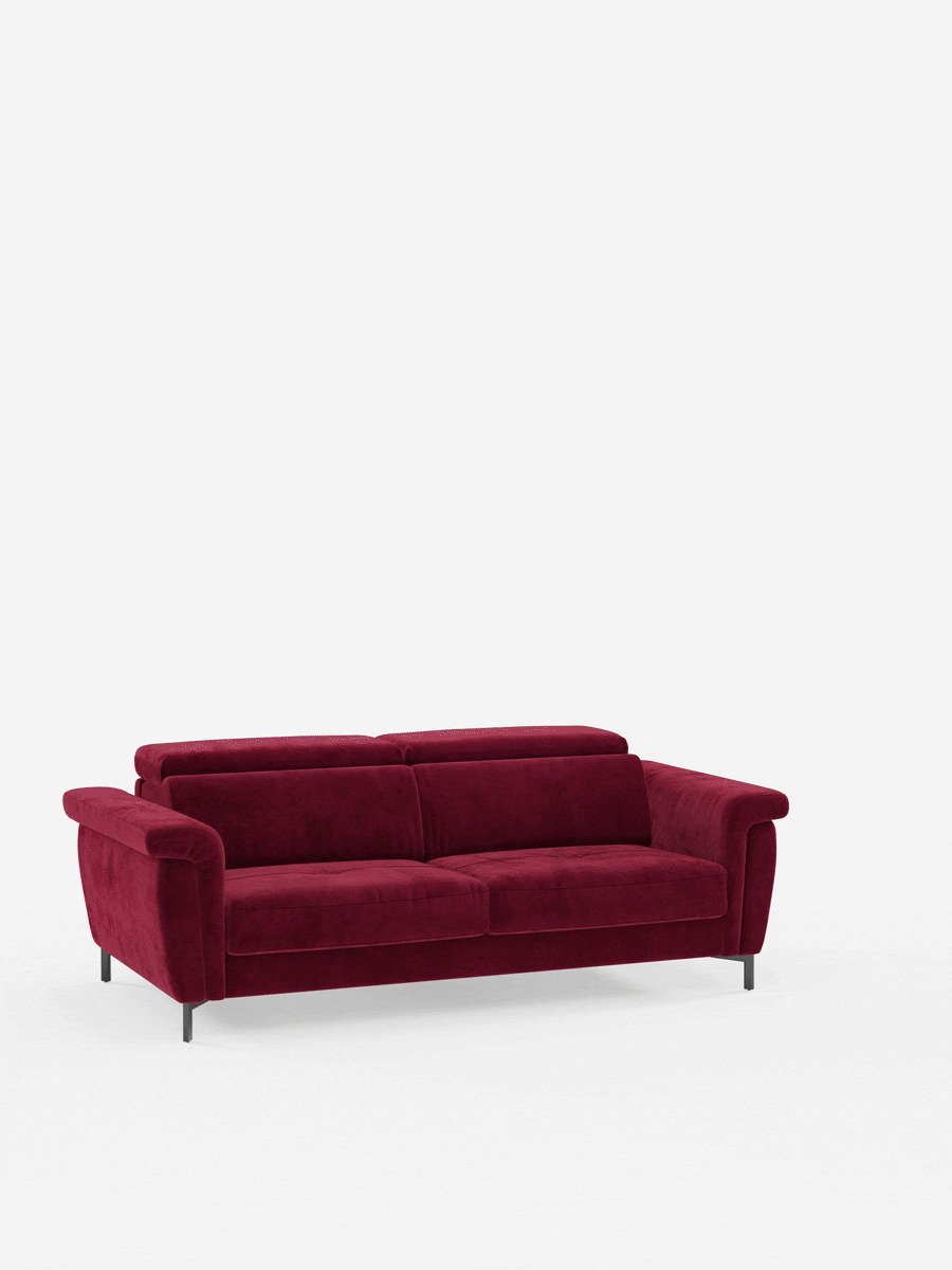 Un divano letto di design contemporaneo della linea Capri di divitt.sbs, caratterizzato da gambe alte e poggiatesta regolabili, rivestito in raffinato tessuto T30 effetto velluto resistente alle macchie, spicca su uno sfondo bianco a tinta unita: il rivestimento rosso intenso e la silhouette moderna ne esaltano il comfort avvolgente e lo stile sofisticato.