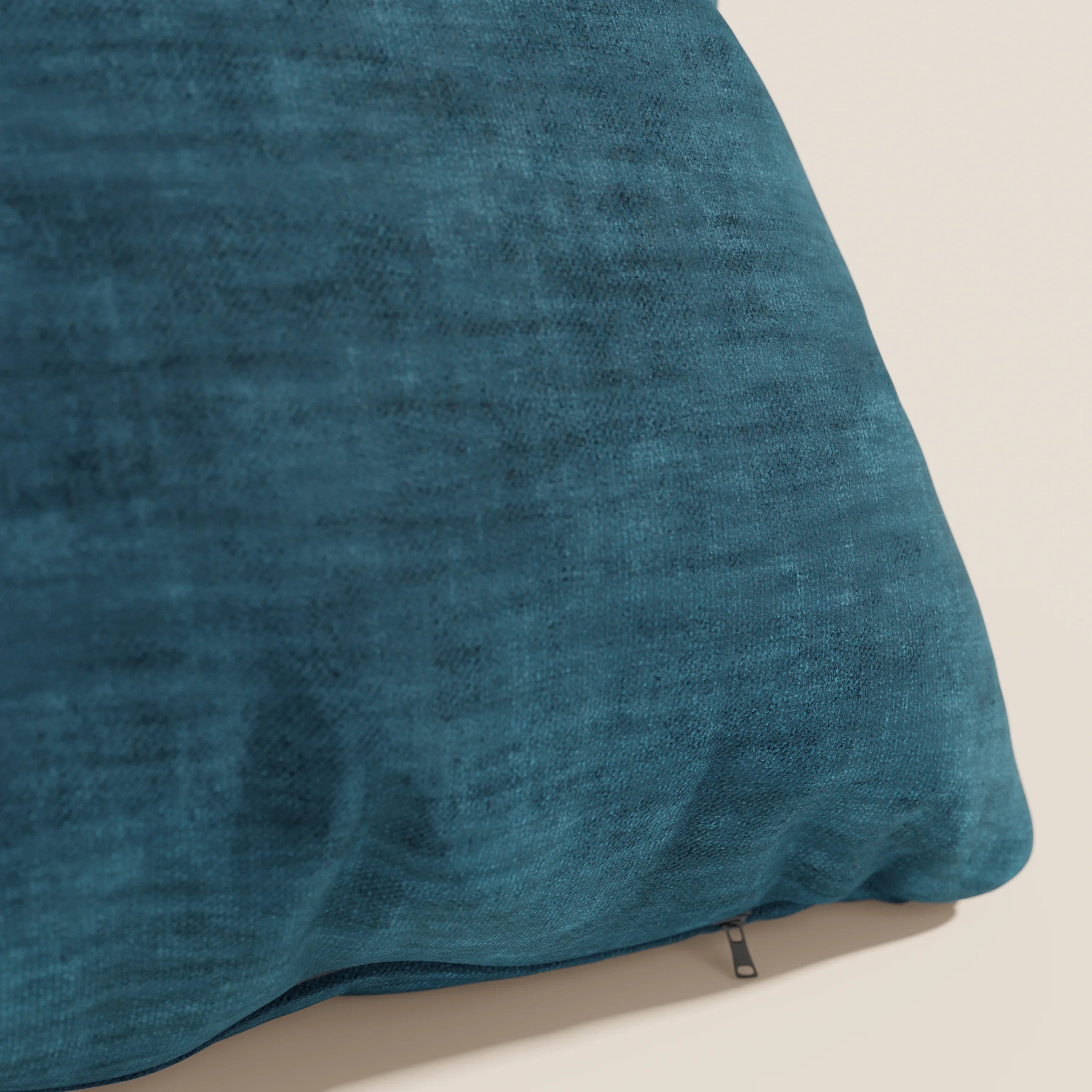 Un primo piano del cuscino Sofia di divitt.sbs, presentato in un grande blu acqua. Realizzato in morbido velluto velato (smacchiabile e impermeabile Easy Clean T35) con cerniera a vista sul fondo, su uno sfondo beige chiaro.