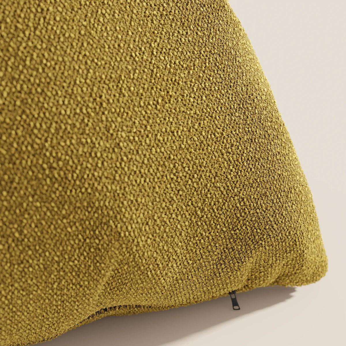 Un primo piano del cuscino Lambada di divitt.sbs in giallo senape, realizzato in tessuto T33 lavabile e impermeabile, fresco e simile al cotone, mostra la sua texture intrecciata e la cerniera a vista su uno sfondo neutro.