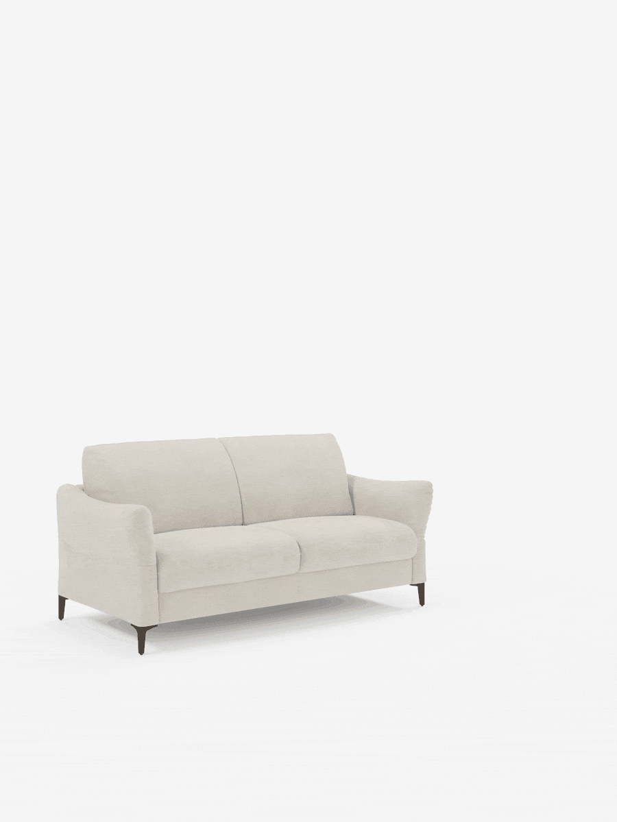 Un divano letto a due posti Dalia, in stile moderno e color beige, firmato divitt.sbs, è posizionato su una superficie bianca. Rivestito in tessuto vellutino T30 antimacchia, il divano presenta morbidi cuscini, braccioli leggermente svasati e gambe angolate in legno. Lo sfondo bianco a tinta unita esalta lo stile pulito e minimalista di questo elegante complemento d'arredo.