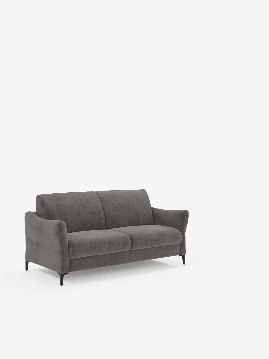 Un moderno divano letto a due posti “Dalia” di divitt.sbs, color grigio scuro, rivestito in tessuto vellutato T30 antimacchia, caratterizzato da sottili gambe nere e posizionato su uno sfondo bianco. Il divano presenta braccioli leggermente inclinati, morbidi cuscini di seduta e schienali leggermente angolati. Non sono visibili altri oggetti o decorazioni.