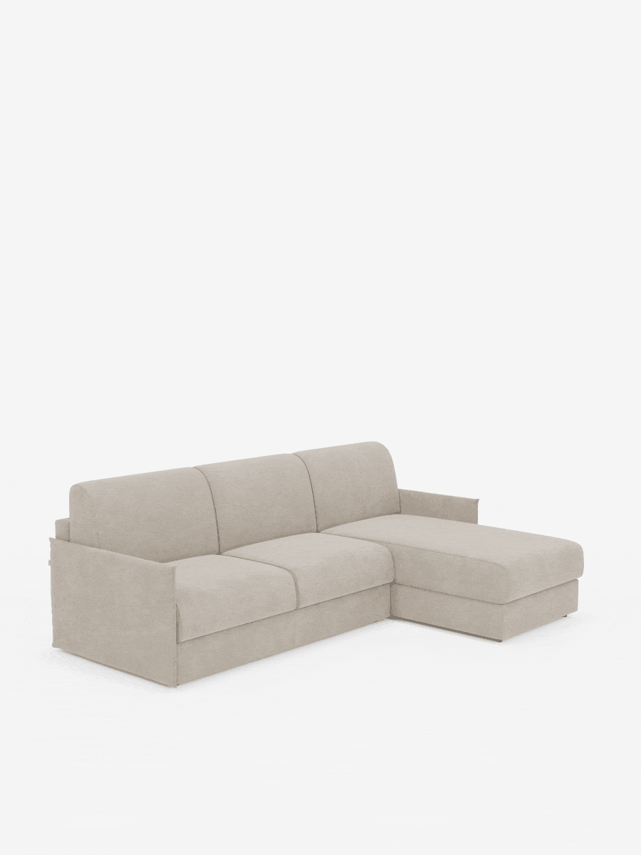 Il divano letto angolare con penisola contenitore Evans di divitt.sbs è esposto su uno sfondo bianco a tinta unita. Questo divano componibile compatto color beige è dotato di tre cuscini di seduta e di una chaise longue sul lato destro, completato da braccioli bassi e ampi e da un rivestimento in tessuto morbido e soffice, in tessuto smacchiabile T23. Il suo design moderno e minimalista coniuga con disinvoltura stile e versatilità: il divano letto angolare si trasforma facilmente in un comodo letto