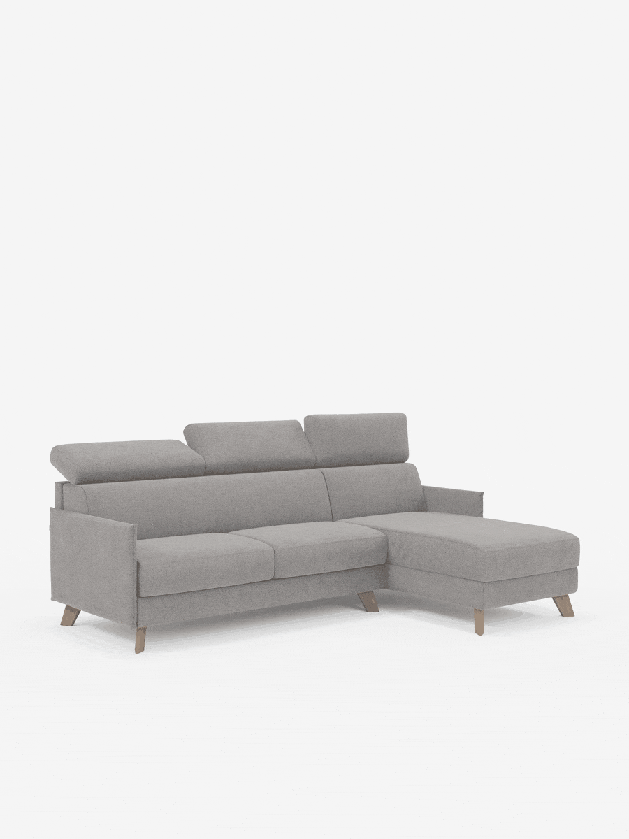 Vi presentiamo il divano letto matrimoniale angolare Sole di divitt.sbs, un moderno divano componibile in stile scandinavo rivestito in tessuto T23 grigio chiaro antimacchia. È dotato di poggiatesta regolabili, gambe in legno dall’elegante inclinazione e una chaise longue sul lato destro con una pratica penisola contenitore per uno spazio aggiuntivo. Lo sfondo bianco minimalista mette in risalto il divano come elemento centrale dell’immagine.