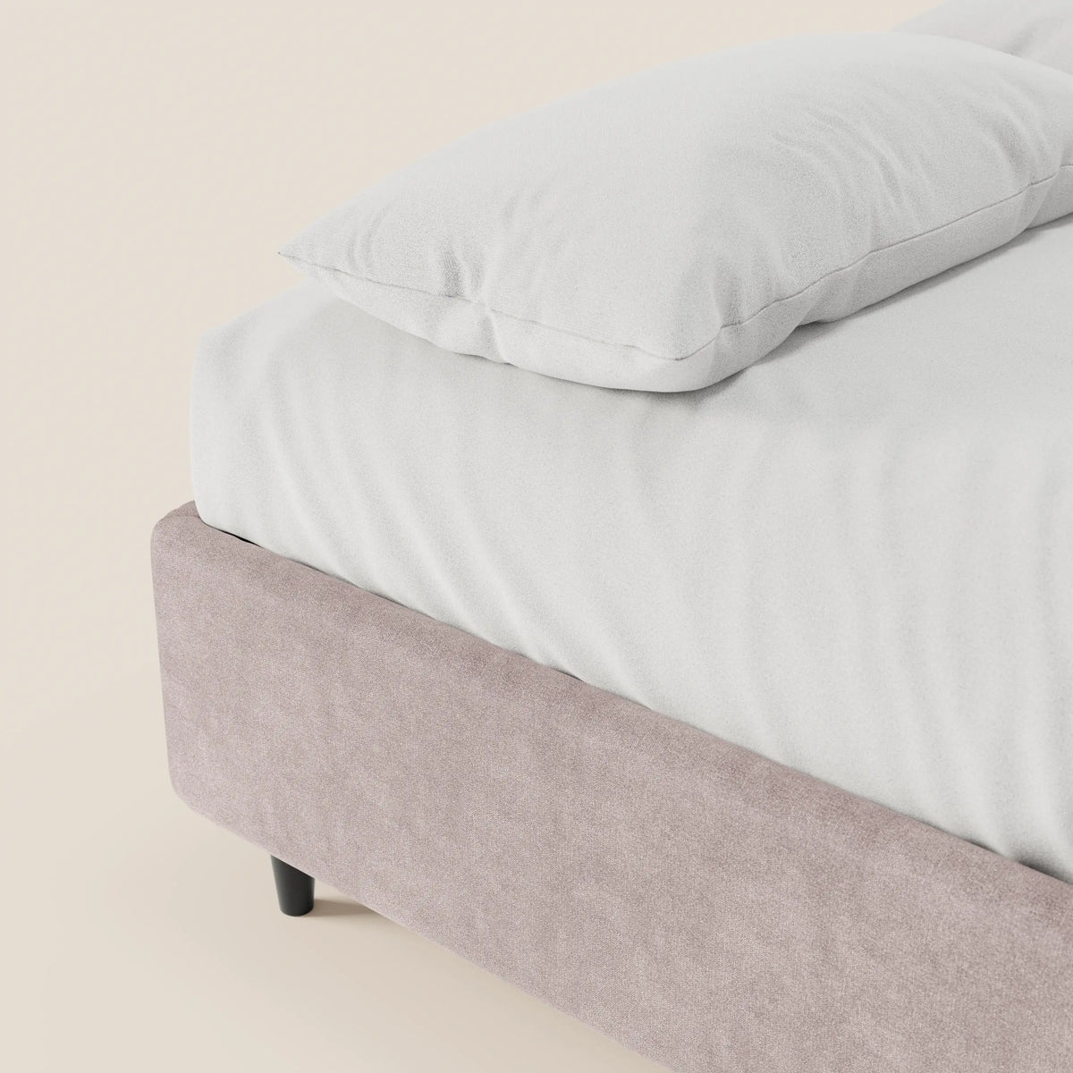 Un primo piano del letto sommier imbottito ERON di Letti.store mette in risalto il suo tessuto impermeabile color beige chiaro, certificato Oeko-Tex, e la base con contenitore, con un cuscino e un lenzuolo bianchi, il tutto su uno sfondo neutro e tenue che conferisce al tutto un look pulito e minimalista.
