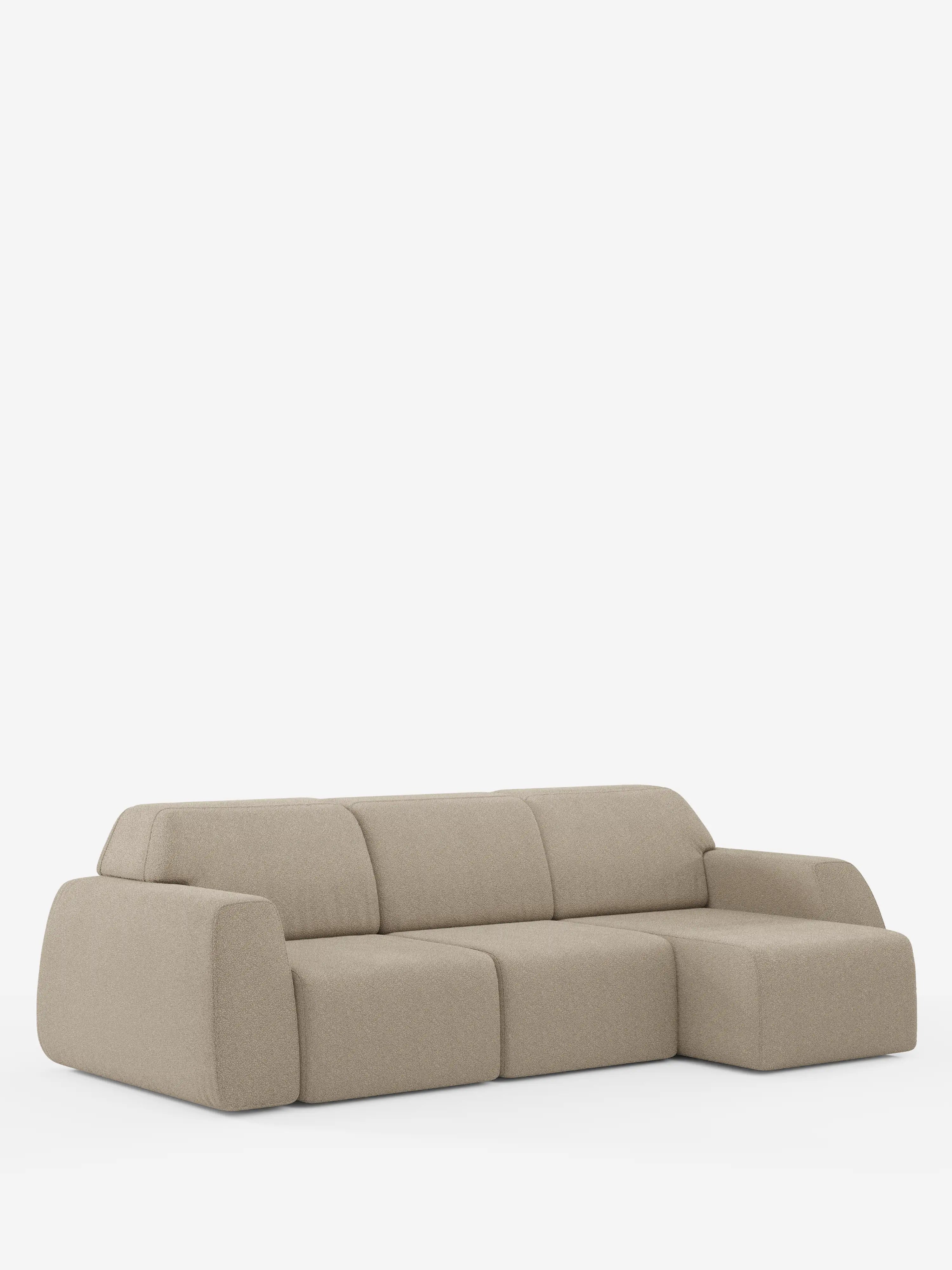 Un divano angolare Orbit contemporaneo, color beige chiaro, con penisola reversibile e tutte le sedute allungabili, rivestito in tessuto smacchiabile effetto cotone T33 di divitt.sbs, caratterizzato da morbidi cuscini arrotondati e da una chaise longue sul lato destro, è esposto su uno sfondo bianco a tinta unita. Le linee morbide e il profilo ribassato ne accentuano il design moderno di alta gamma.