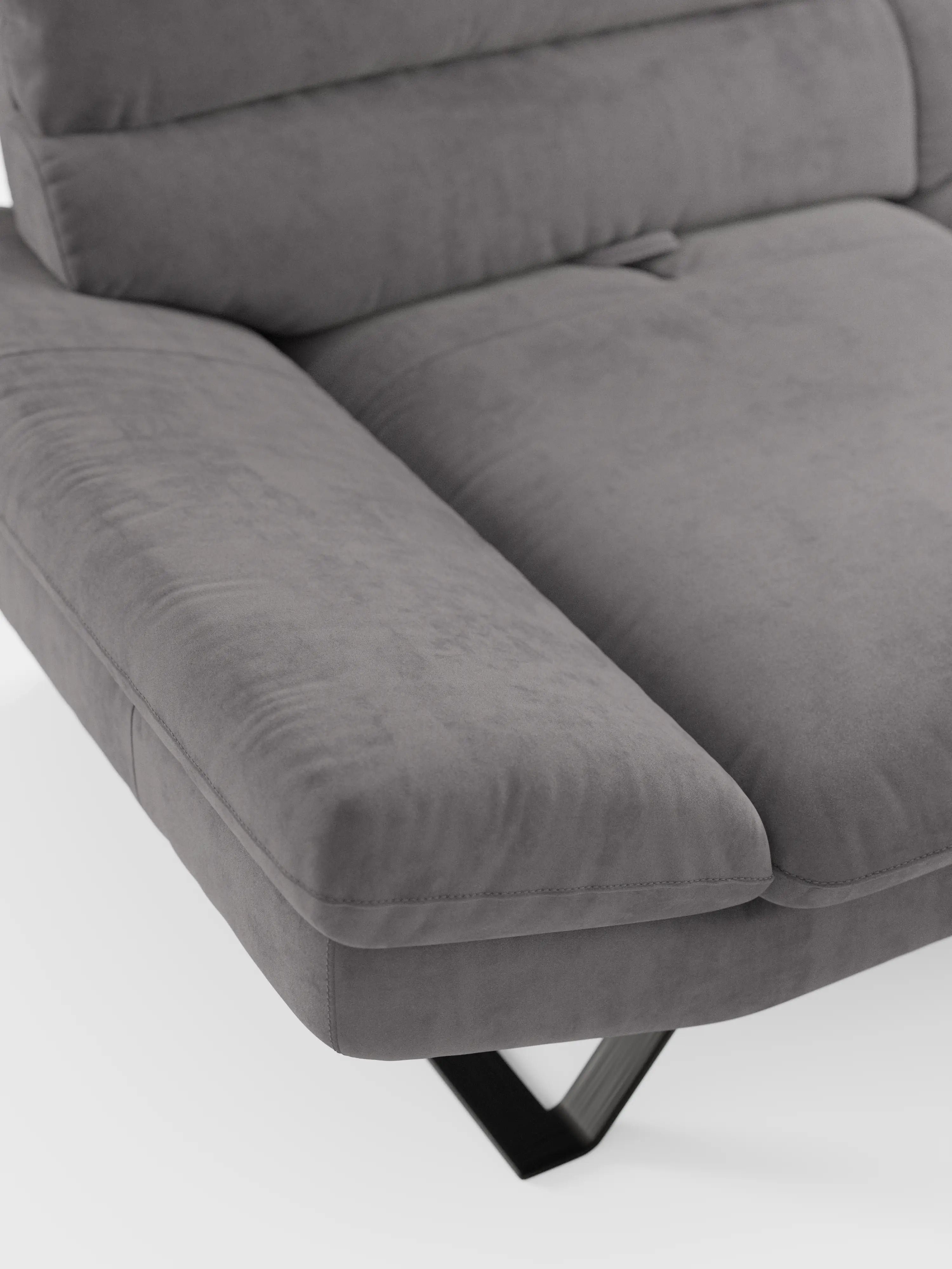 Primo piano del divano Eclipse dal design moderno a 2 e 3 posti con schienali traslanti di divitt.sbs, che mette in risalto la sua imbottitura morbida, i braccioli angolati e il rivestimento in microfibra T11 smacchiabile, con texture a vista. Questo divano contemporaneo presenta eleganti gambe alte in metallo nero a forma di V ed è messo in risalto su uno sfondo bianco a tinta unita.