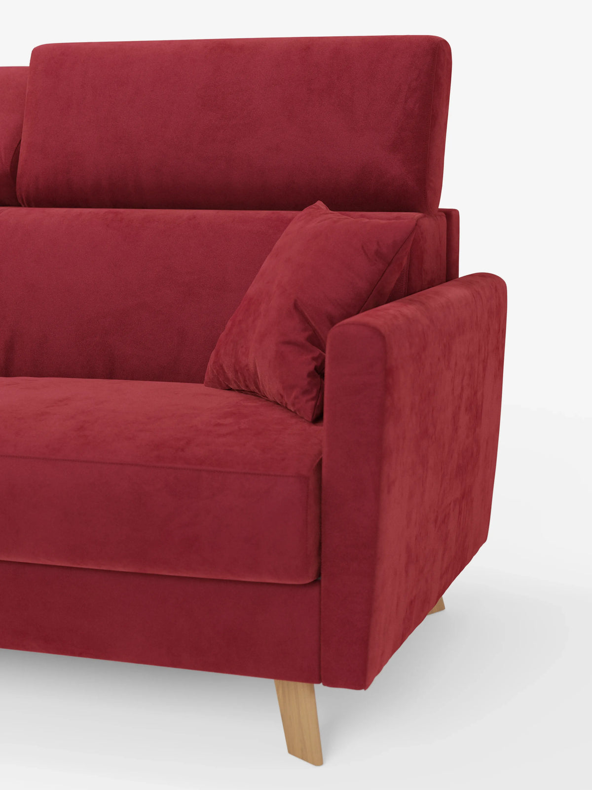 Un primo piano del divano letto Francy con poggiatesta regolabili di divitt.sbs, un moderno divano a tre posti in velluto rosso dotato di un unico cuscino di seduta, un cuscino decorativo e gambe in legno. Il bracciolo è ampio e imbottito, mentre lo sfondo è bianco a tinta unita. Questo modello è sfoderabile al 100% e rivestito con l'elegante tessuto T30 resistente alle macchie.