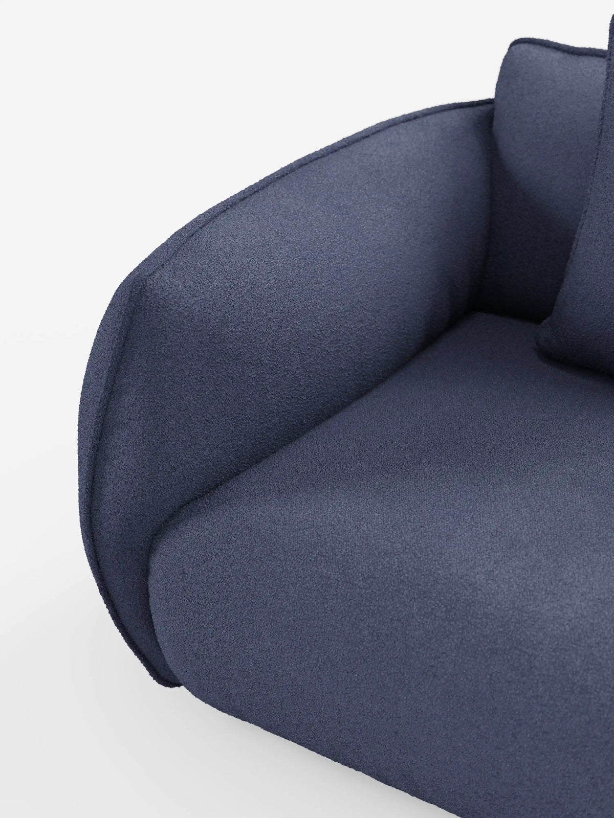 Primo piano del divano Nimbus a 3 posti, modulare e componibile, da 250 cm di divitt.sbs, caratterizzato da un'imbottitura morbida e da bordi arrotondati, rivestito in tessuto effetto cotone blu scuro, sfoderabile e antimacchia (t33). Il bracciolo e la seduta, di notevole spessore, sono completati da un cuscino coordinato, parzialmente visibile su uno sfondo bianco a tinta unita.