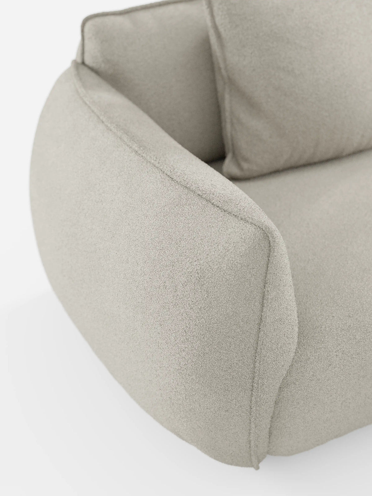 Primo piano del divano angolare con penisola componibile Nimbus di divitt.sbs, rivestito in morbido tessuto T33 antimacchia con una trama effetto cotone. Il rivestimento beige chiaro presenta un aspetto delicato e strutturato, mentre il design è caratterizzato da bordi lisci e arrotondati che conferiscono al divano un’estetica accogliente e contemporanea. Lo sfondo bianco mette in risalto l’eleganza del complemento d’arredo.