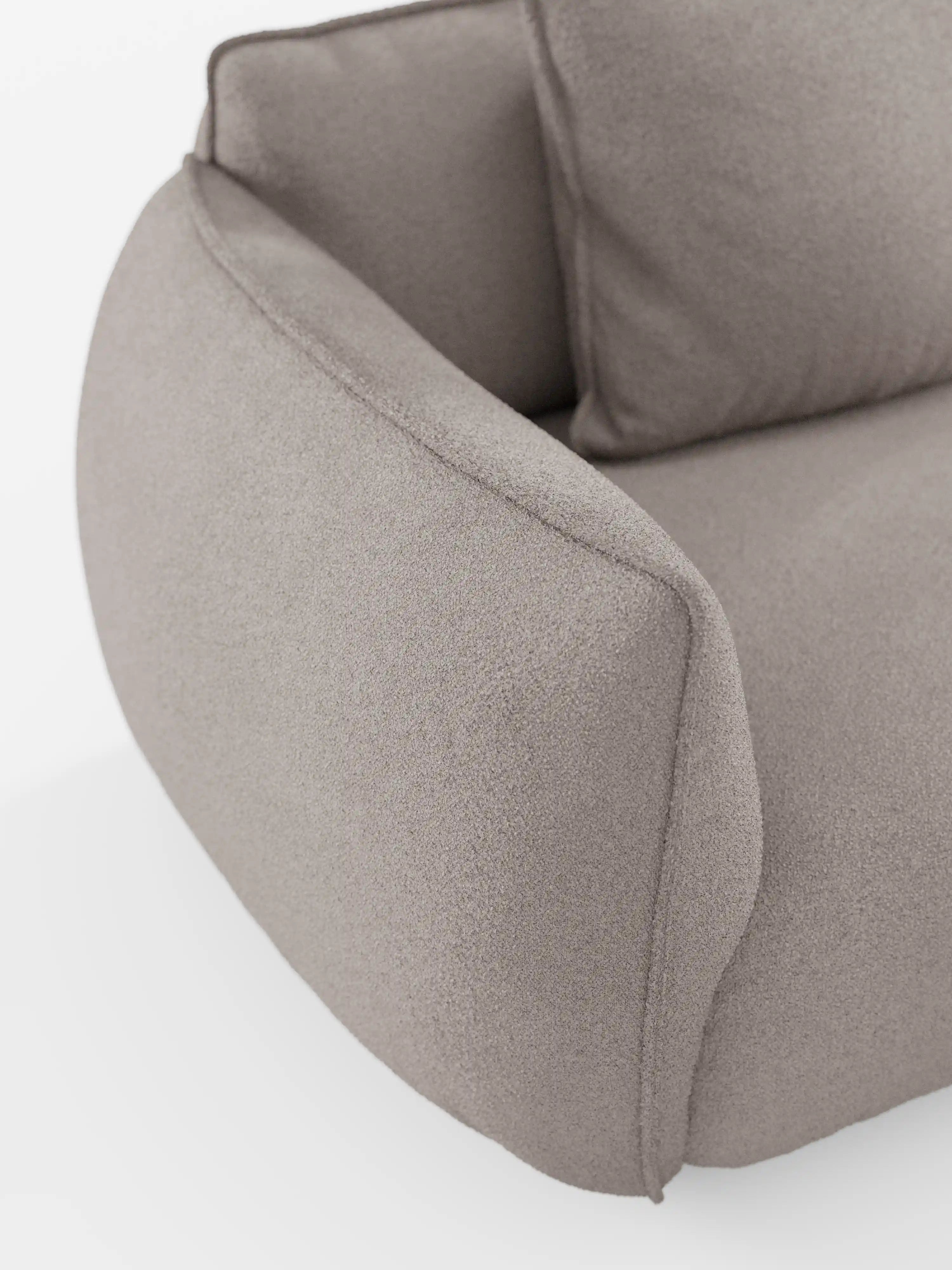 Primo piano del divano angolare con penisola componibile Nimbus di divitt.sbs, rivestito in tessuto grigio chiaro, morbido, effetto cotone e resistente alle macchie (T33). Il design moderno è caratterizzato da linee morbide e arrotondate, con braccioli e schienale delicatamente ricurvi, che richiamano i contorni eleganti tipici dei divani moderni o modulari. Il tutto su uno sfondo bianco a tinta unita.