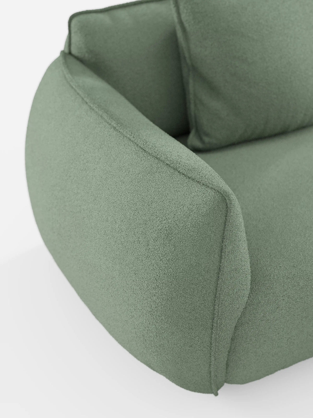 Un primo piano del divano angolare con penisola componibile Nimbus di divitt.sbs ne mette in risalto il design moderno nella tonalità verde chiaro, rivestito in morbido tessuto T33 effetto cotone, dalla trama ruvida e resistente alle macchie. Caratterizzato da braccioli arrotondati e cuciture senza cuciture che richiamano l’estetica di un divano moderno contemporaneo, questo modello è messo in risalto su uno sfondo bianco a tinta unita per enfatizzarne le linee morbide ed eleganti.