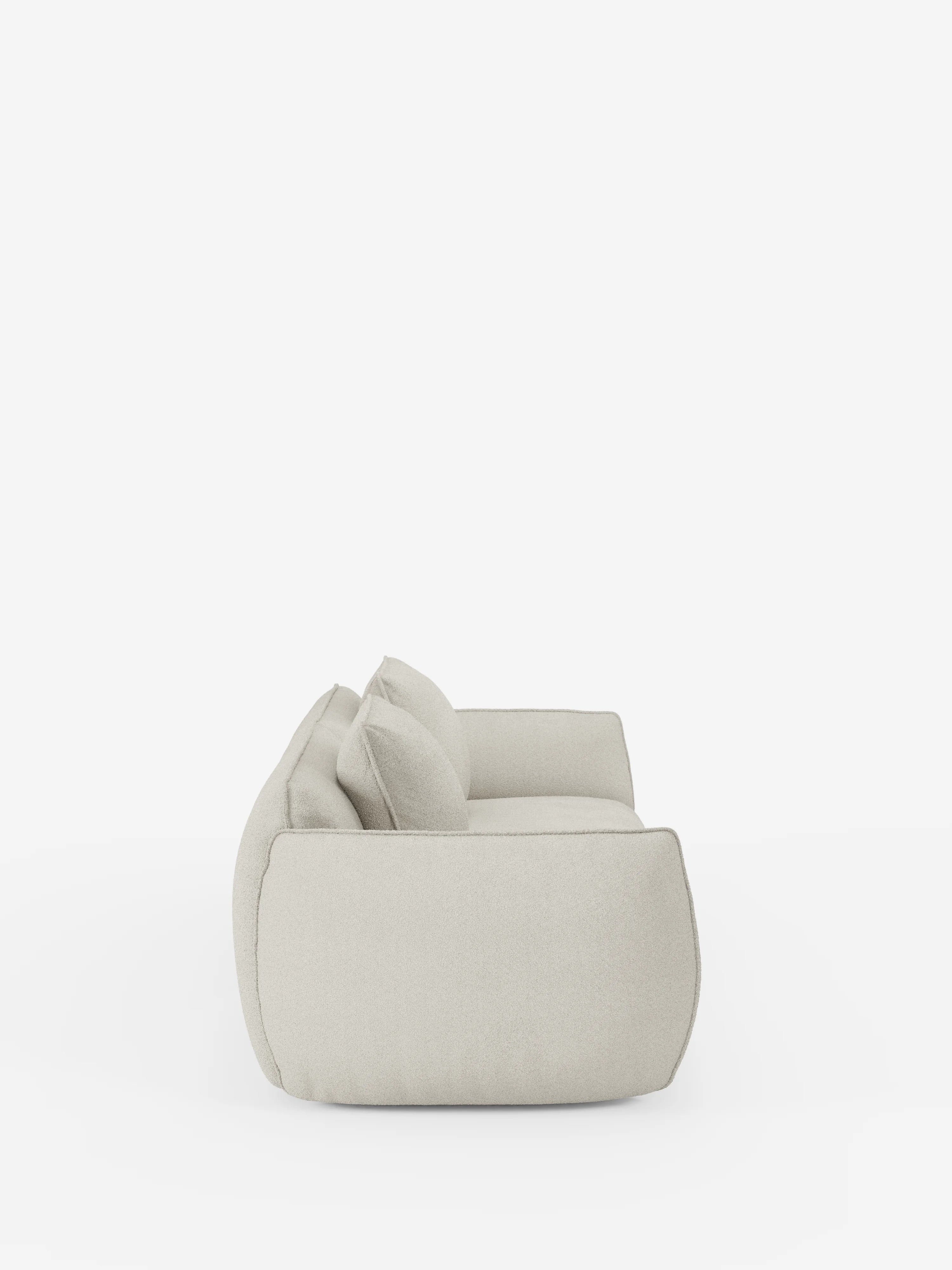 Vista laterale del divano modulare e componibile a 3 posti Nimbus da 250 cm di divitt.sbs, rivestito in tessuto T33 effetto cotone, colore beige chiaro e resistente alle macchie. Questo divano modulare è dotato di due cuscini di seduta e due cuscini dello schienale, dall’aspetto morbido e soffice, e di braccioli arrotondati, il tutto raffigurato su uno sfondo bianco a tinta unita.